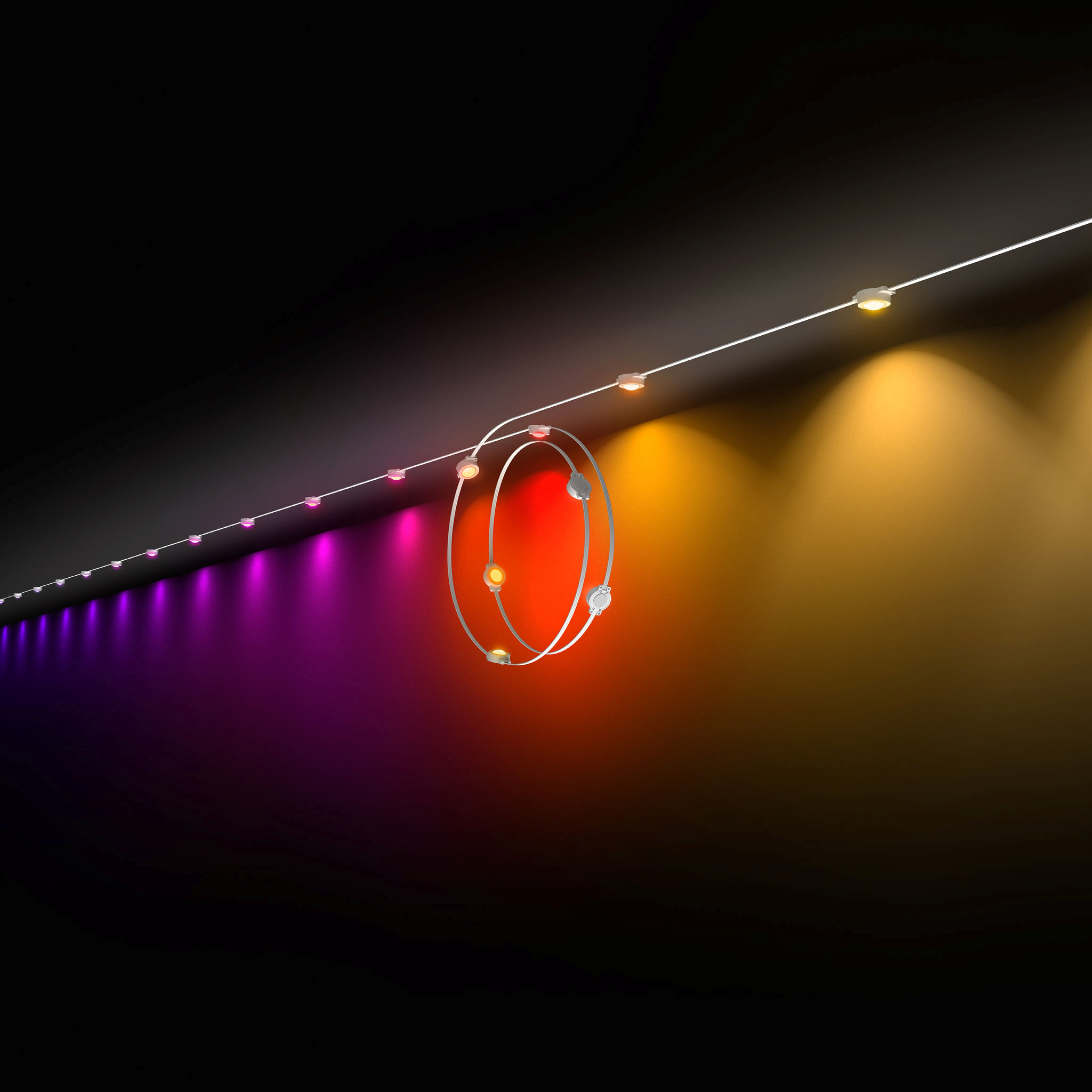 Una catena di luci LED calde e viola proietta luce colorata contro una parete scura.