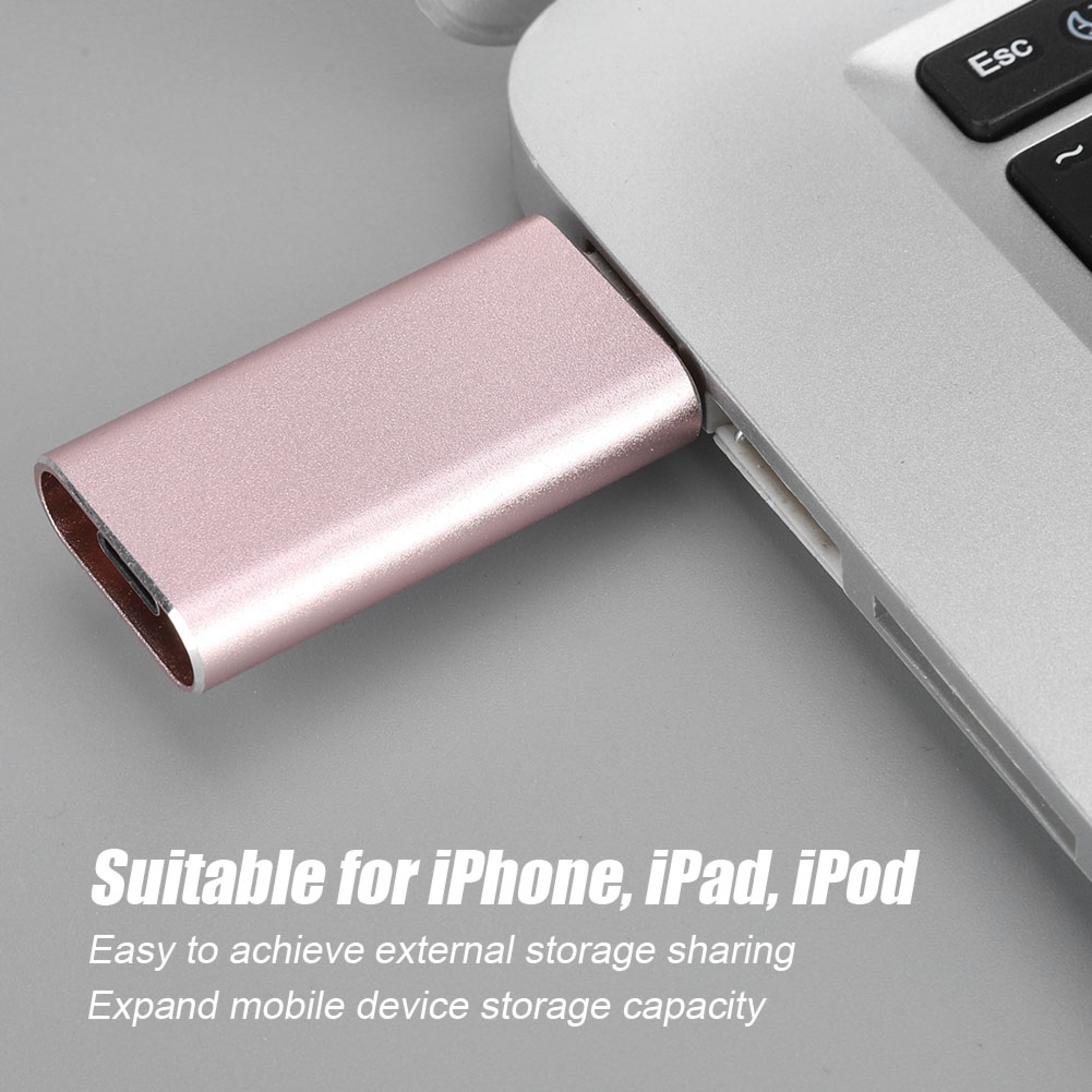 Ein roségoldener USB-Adapter steckt in einem grauen Laptop.