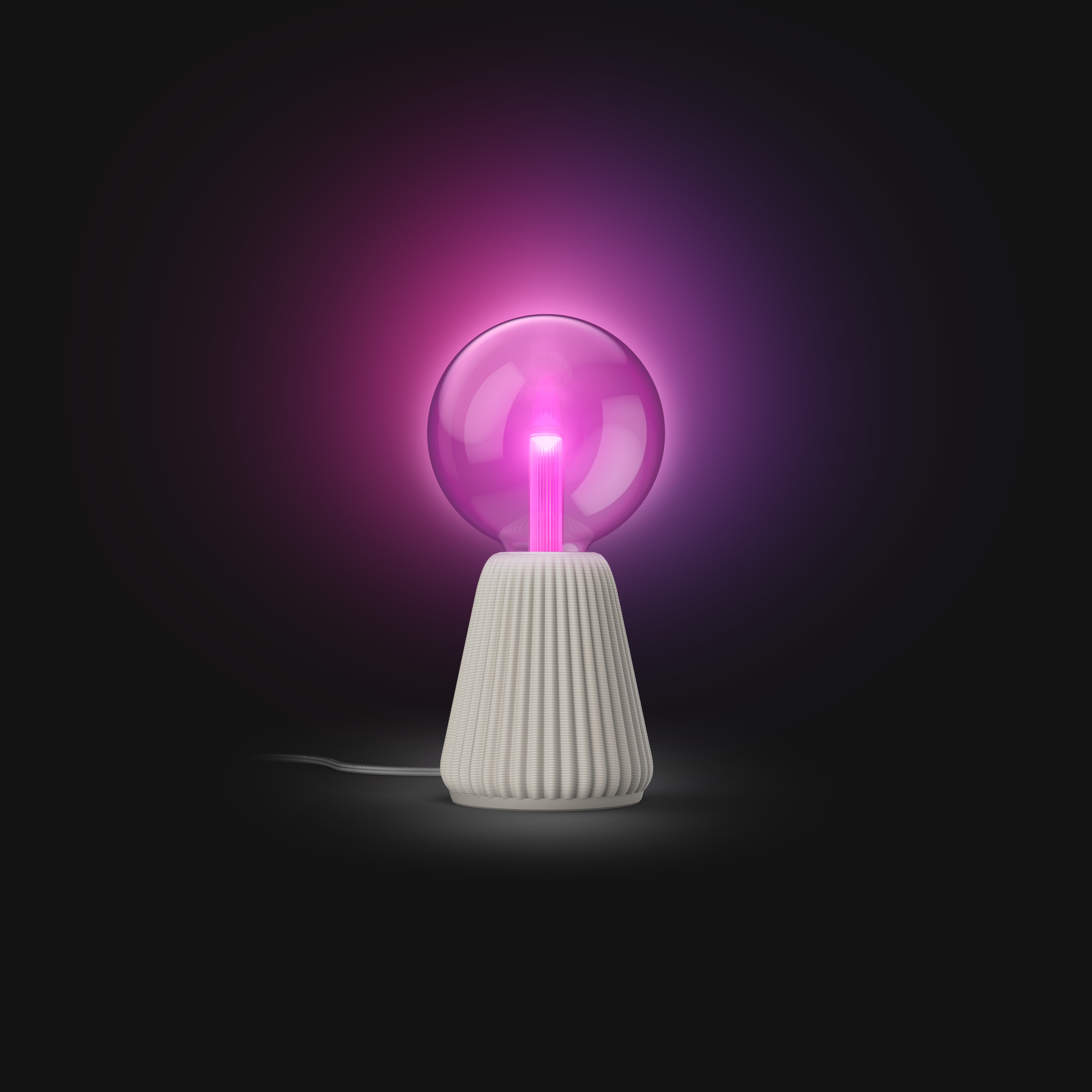 Una lampada rotonda con base bianca scanalata brilla di rosa vibrante su sfondo scuro.
