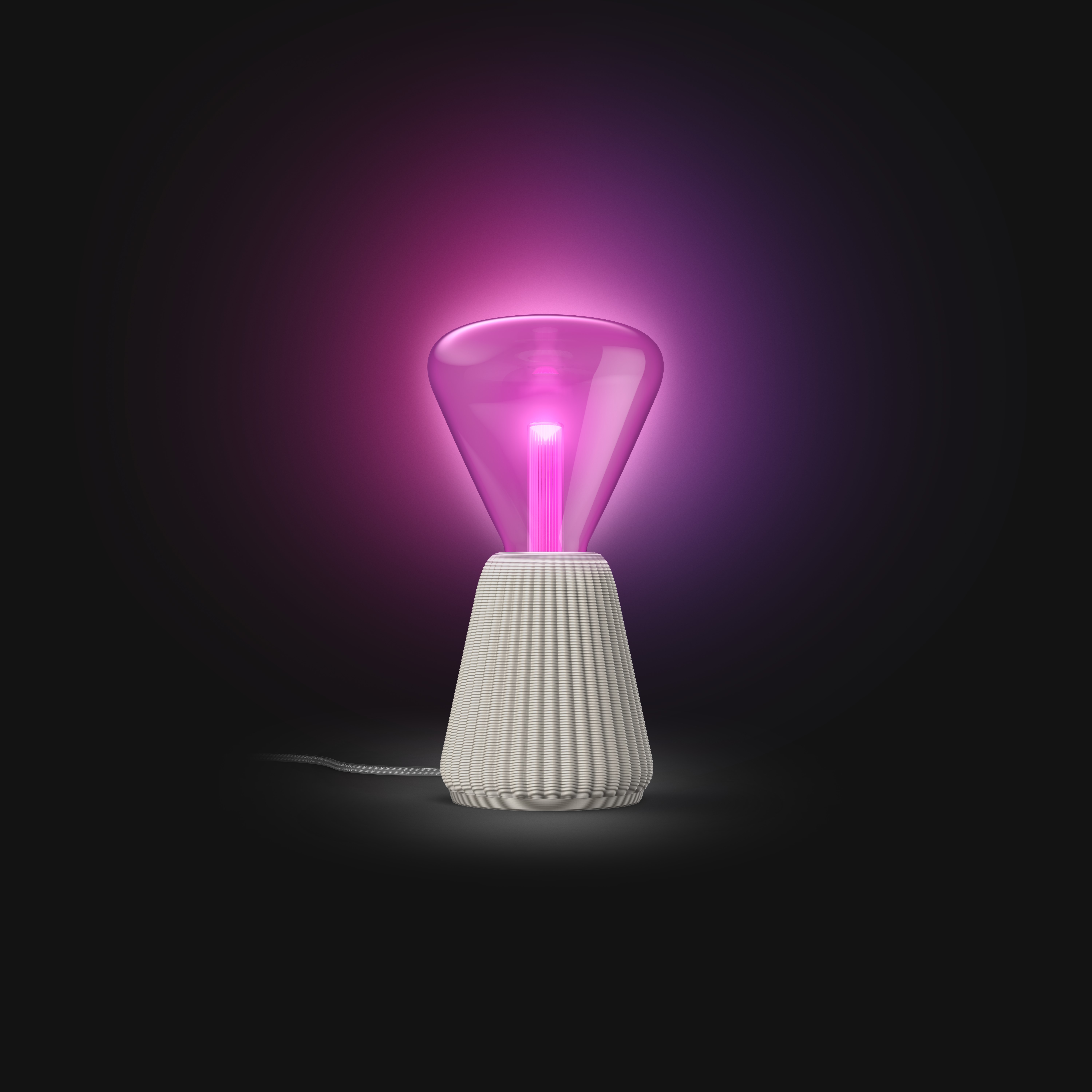 Una moderna lampada da tavolo con base scanalata bianca e lampadina in vetro rosa luminoso su sfondo scuro.