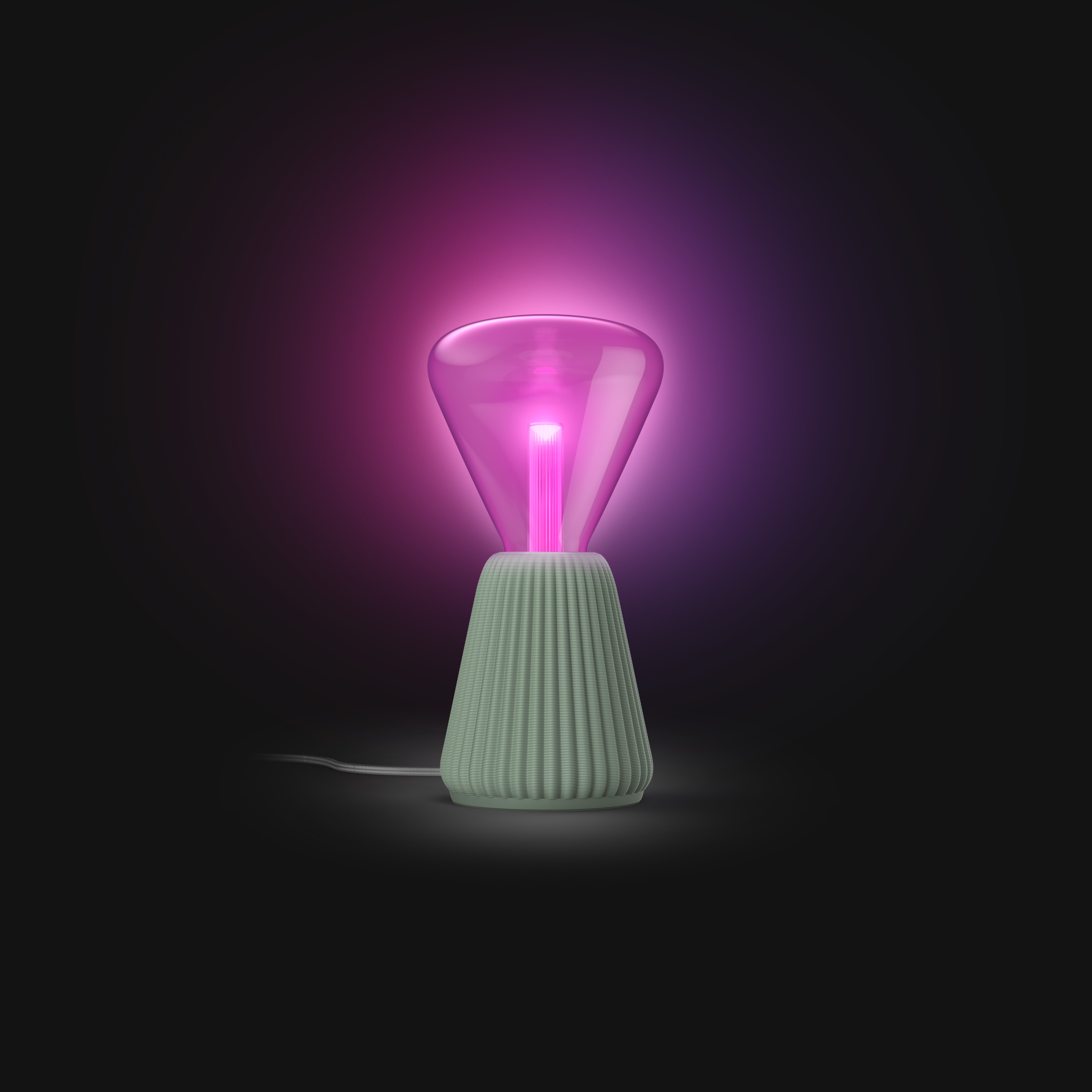 Una moderna lampada da tavolo con base scanalata e paralume in vetro rosa luminoso su sfondo nero.