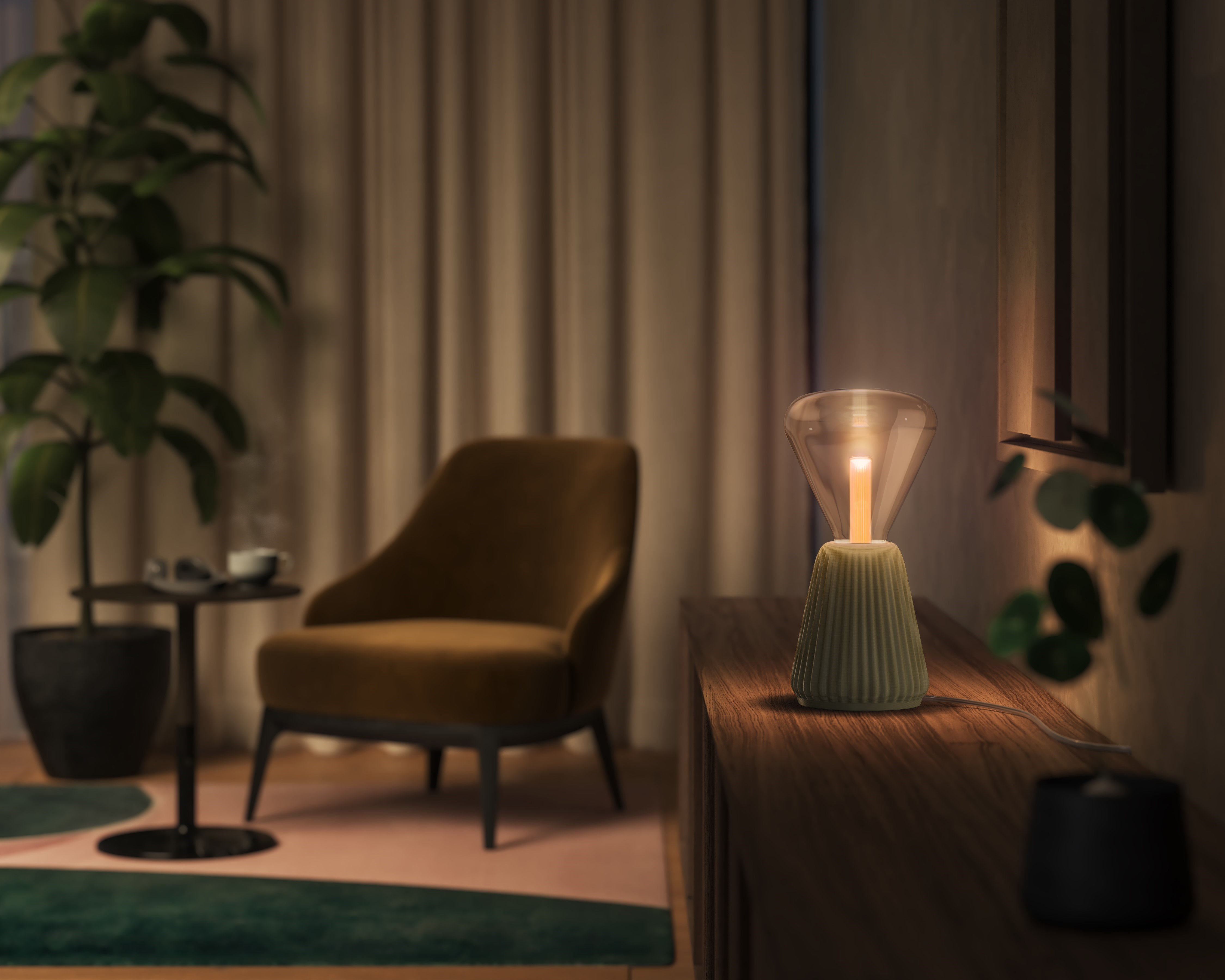 Una lampada da tavolo verde è su un mobile in legno in una stanza con poltrona e piante.