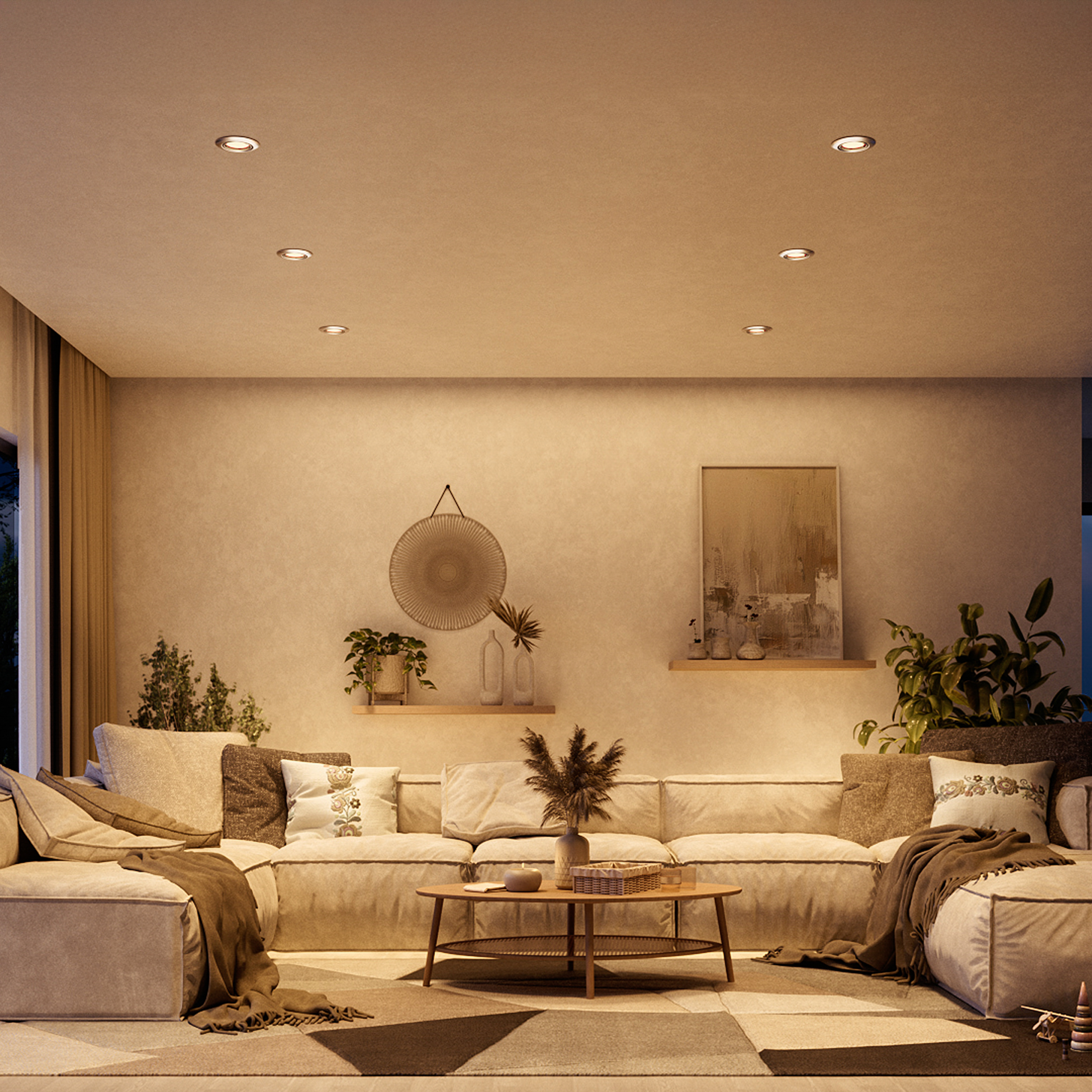 Soggiorno illuminato caldamente con divano angolare beige, tavolino rotondo in legno, piante e quadri.
