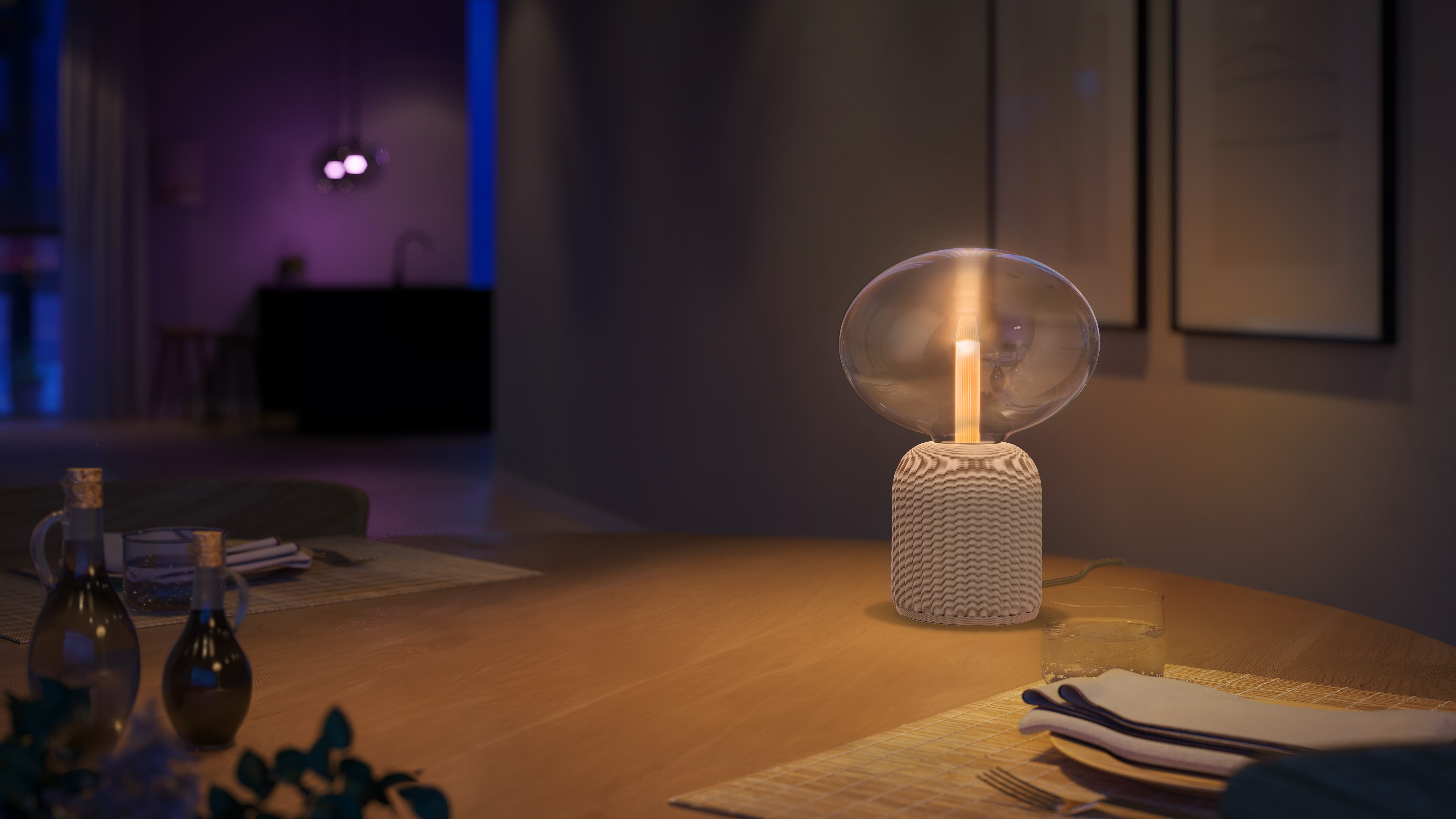 Una moderna lampada da tavolo con paralume in vetro si illumina su un tavolo di legno in una stanza accogliente.