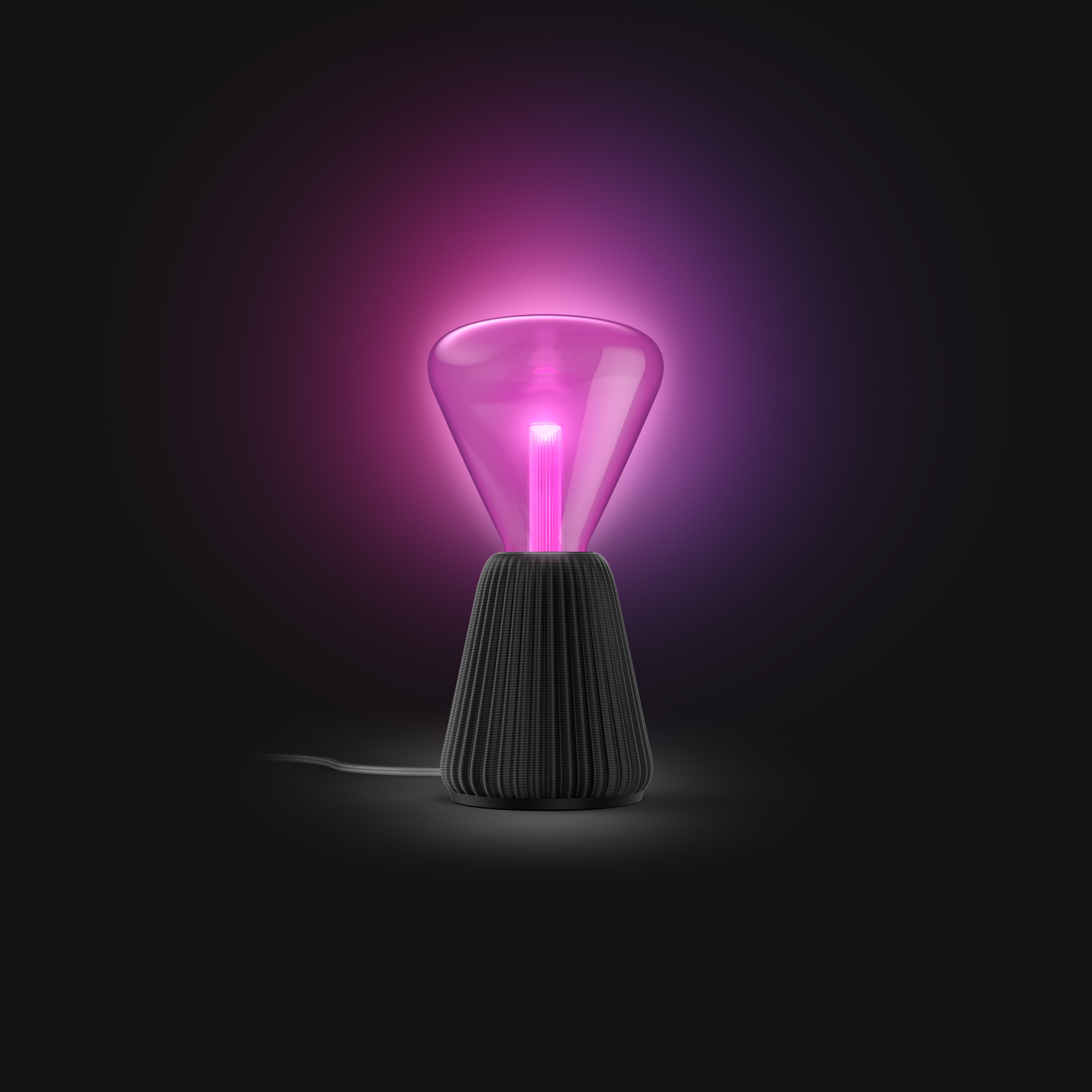 Una moderna lampada da tavolo con base scura scanalata e vetro superiore viola luminoso su sfondo nero.