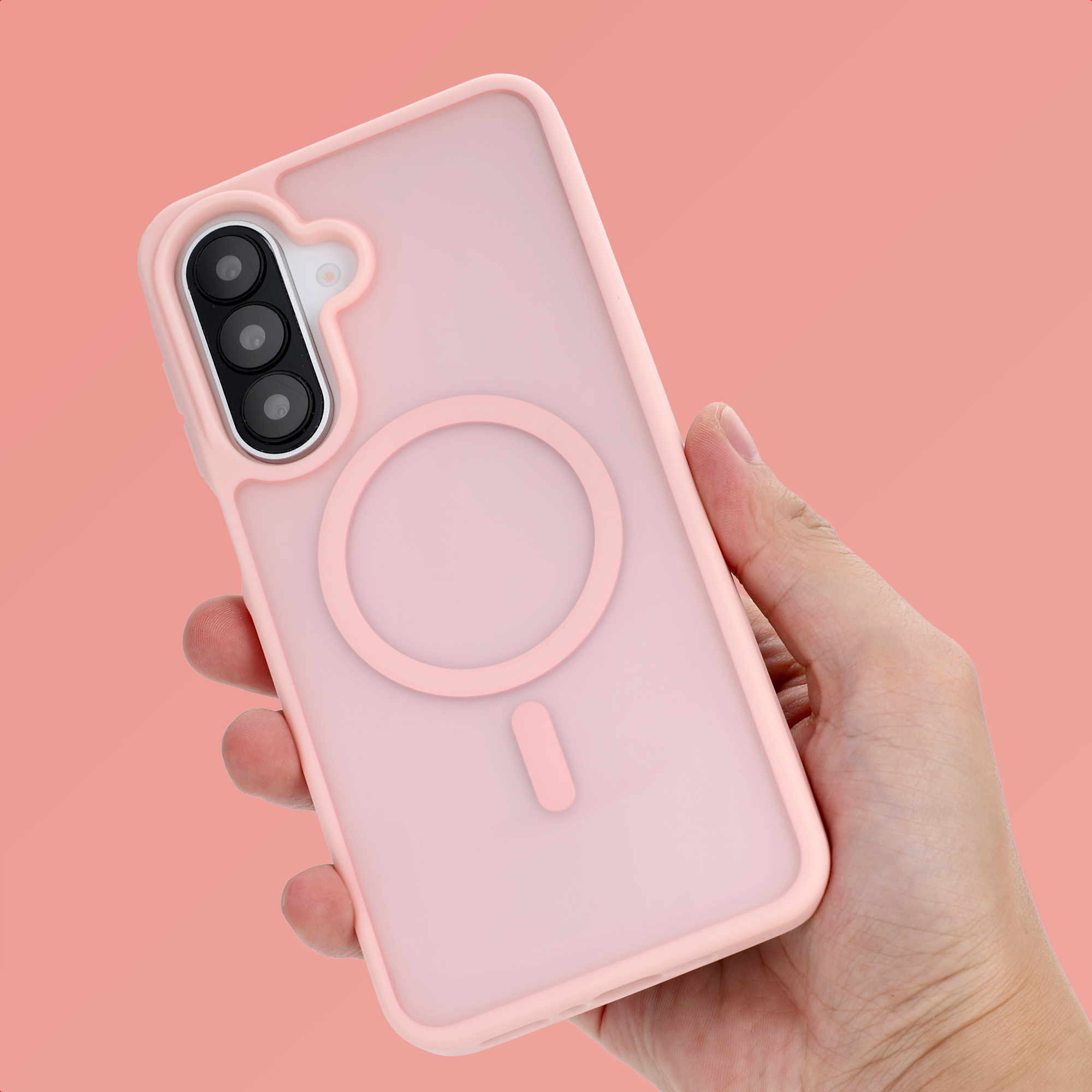 Eine Hand hält eine pinke Handyhülle mit MagSafe-Ring vor rosa Hintergrund.