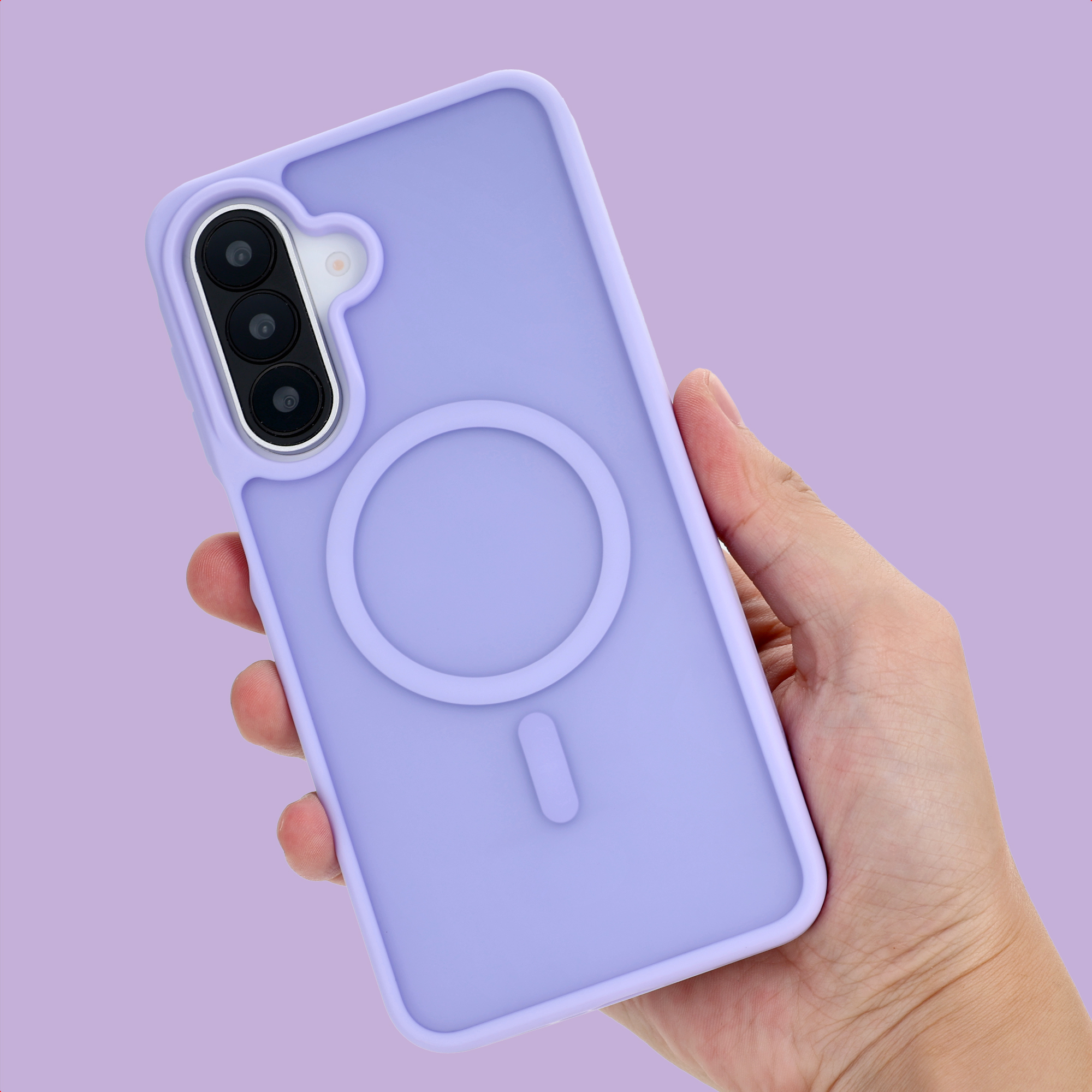 Eine Hand hält ein lila Smartphone mit dreifacher Kamera und MagSafe-Ring auf lila Hintergrund.
