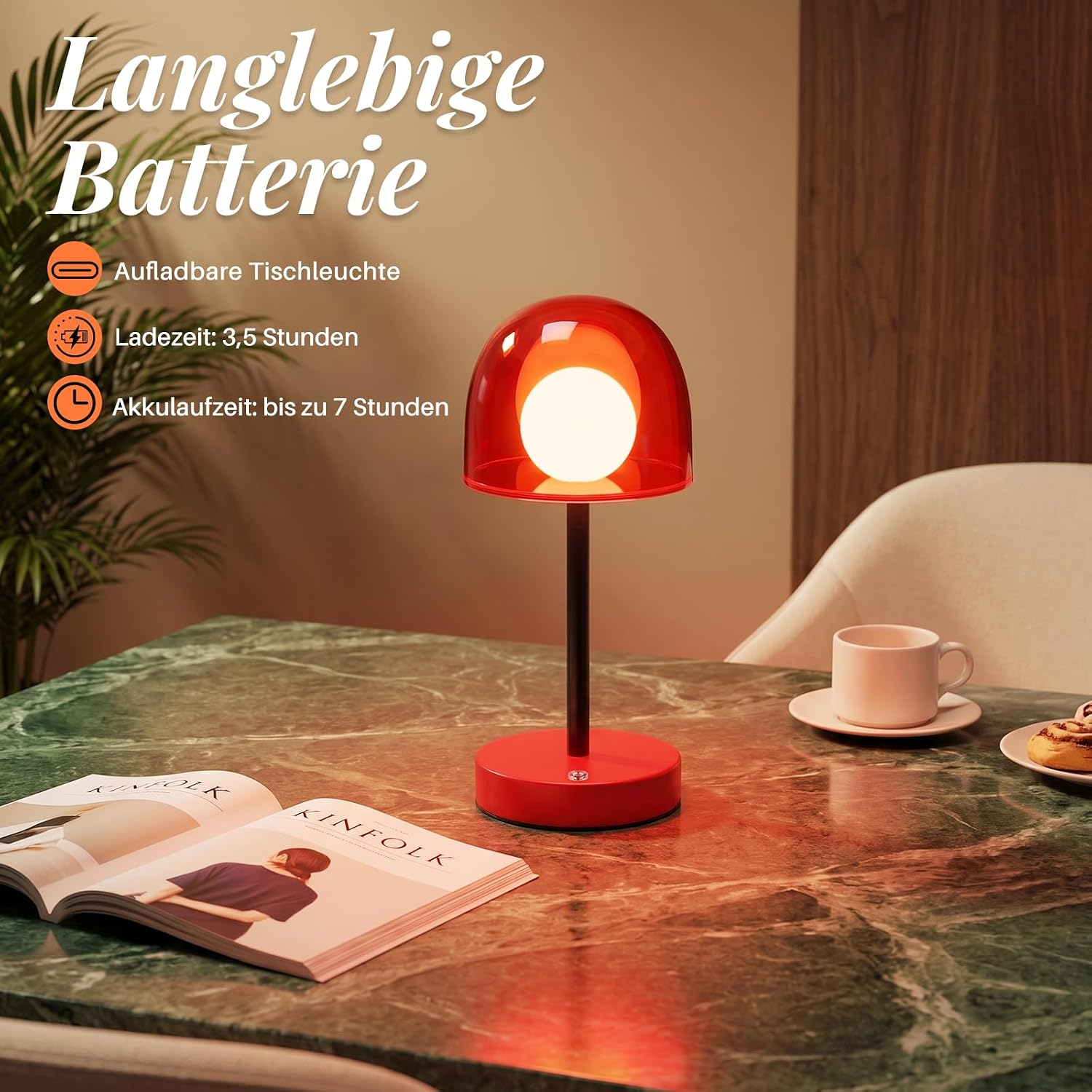 Eine rote Tischlampe steht auf einem Marmortisch neben einer Zeitschrift und einer Tasse.
