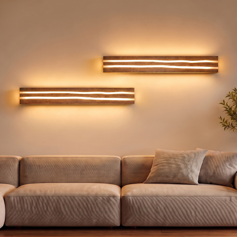 Zwei horizontale, holzverkleidete Wandlampen leuchten über einem hellen Sofa mit Kissen in einem gemütlichen Raum.