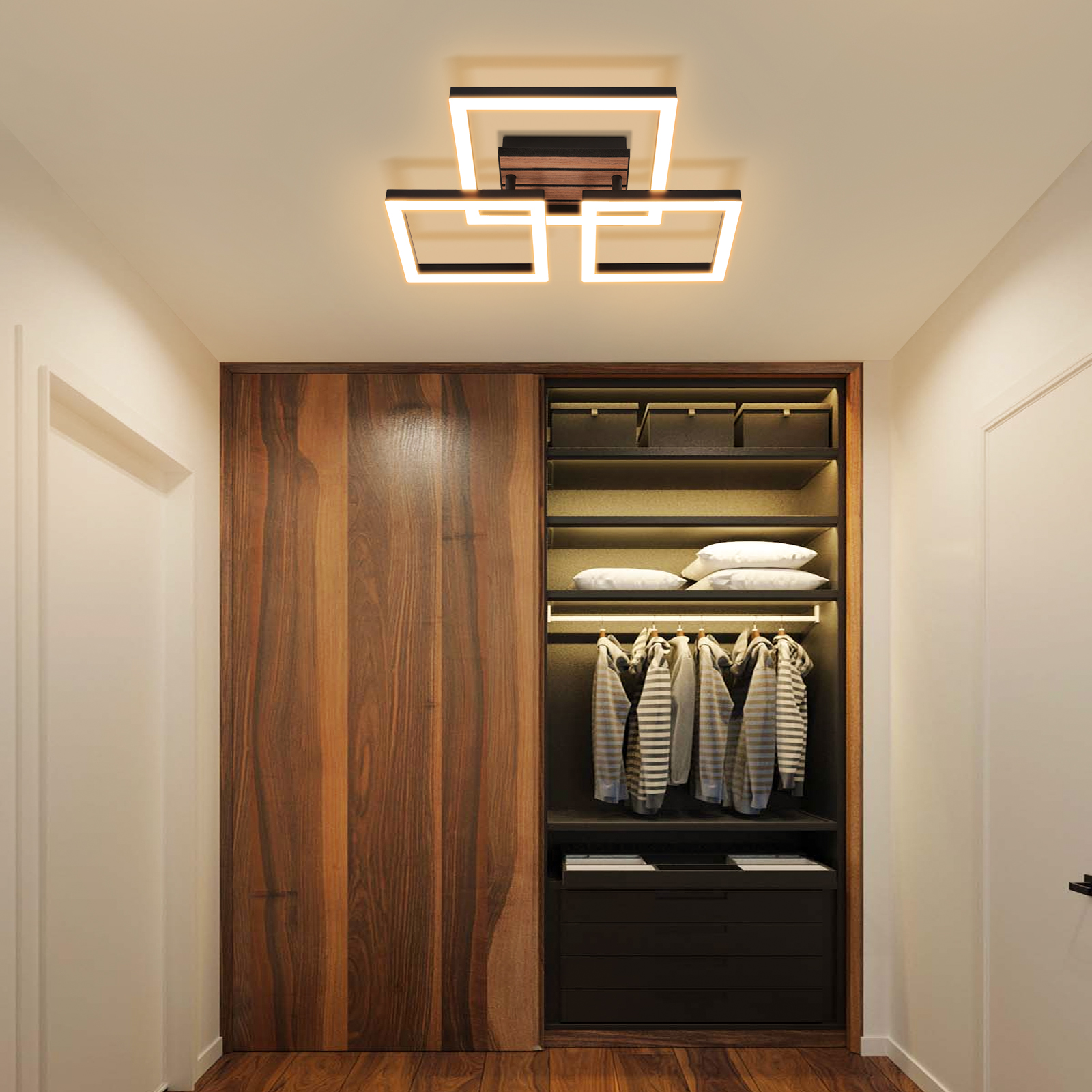 Flur mit quadratischer Deckenleuchte, großem Holzschrank mit Kleidung und weißen Wänden.
