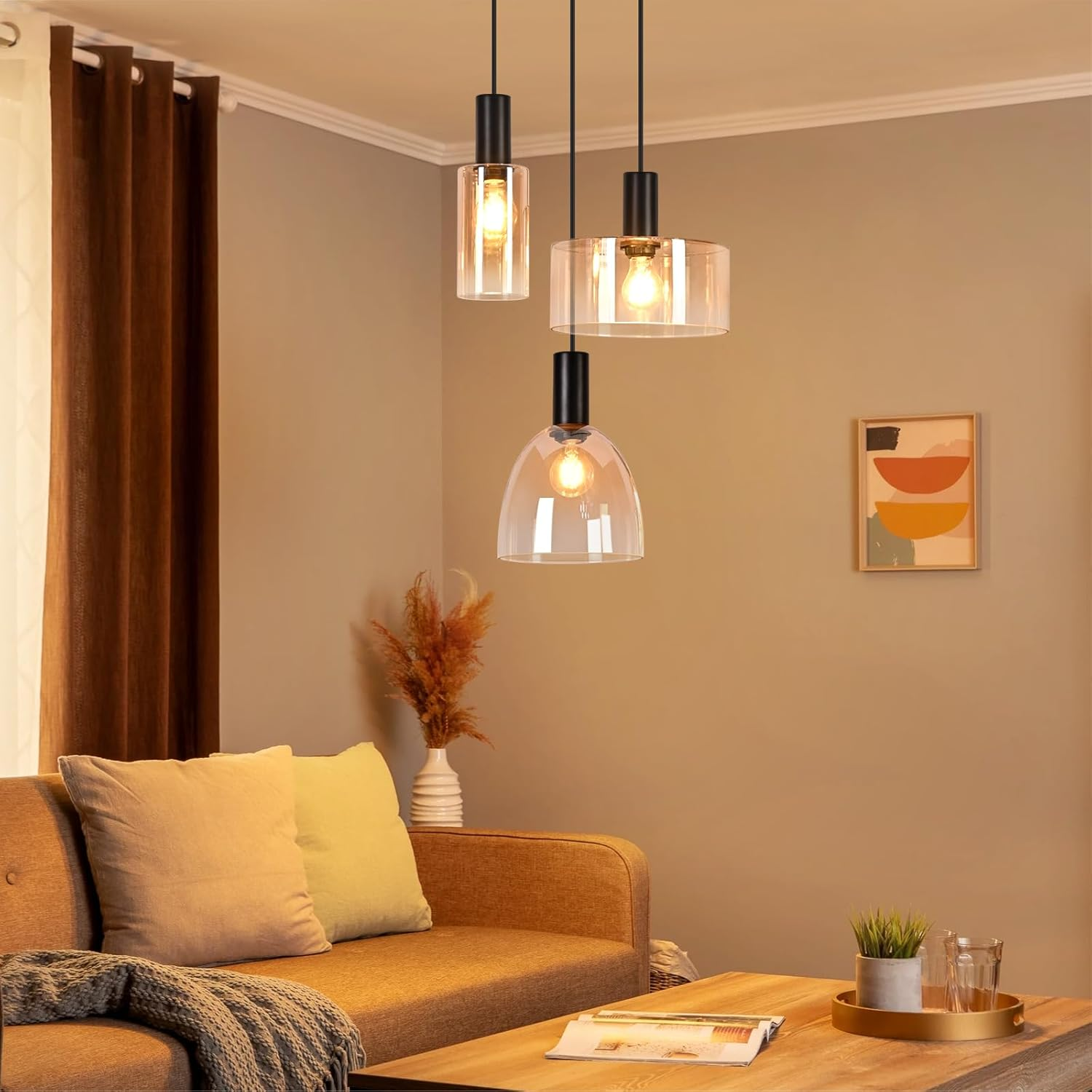 Drei moderne Hängelampen mit Glasschirmen leuchten über einem Sofa und einem Holztisch in einem Wohnzimmer.