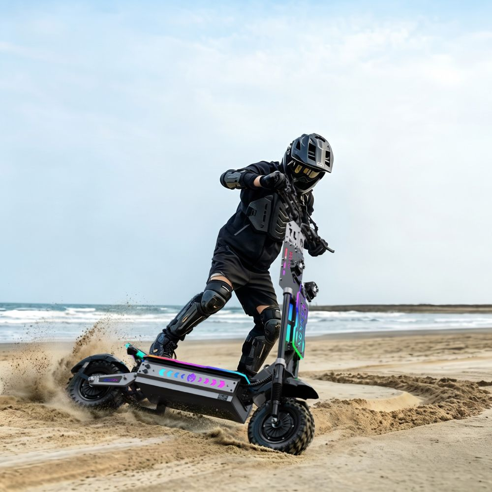 Un pilota con casco e ginocchiere sfreccia su un monopattino elettrico sulla spiaggia sabbiosa con oceano.