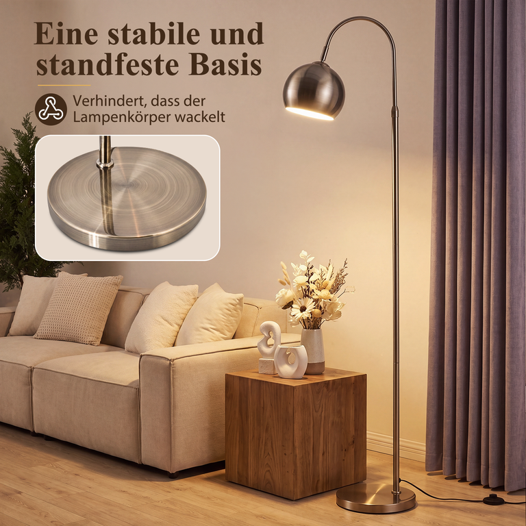 Eine Bogenlampe mit stabiler Basis steht neben einem Sofa in einem Wohnzimmer.