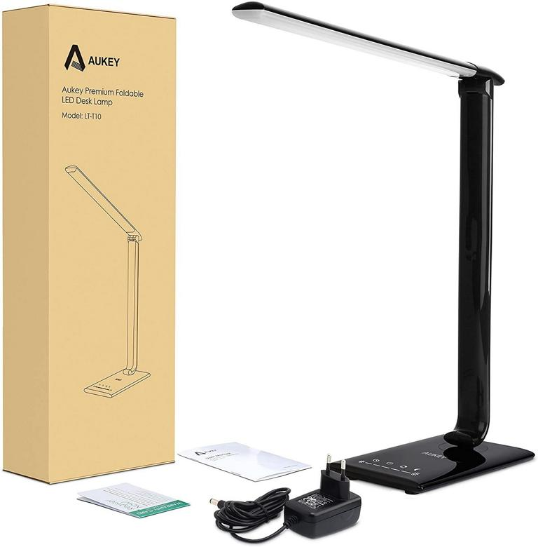 Schwarze LED-Schreibtischlampe mit Box, Netzkabel und Anleitungen auf weißem Grund.