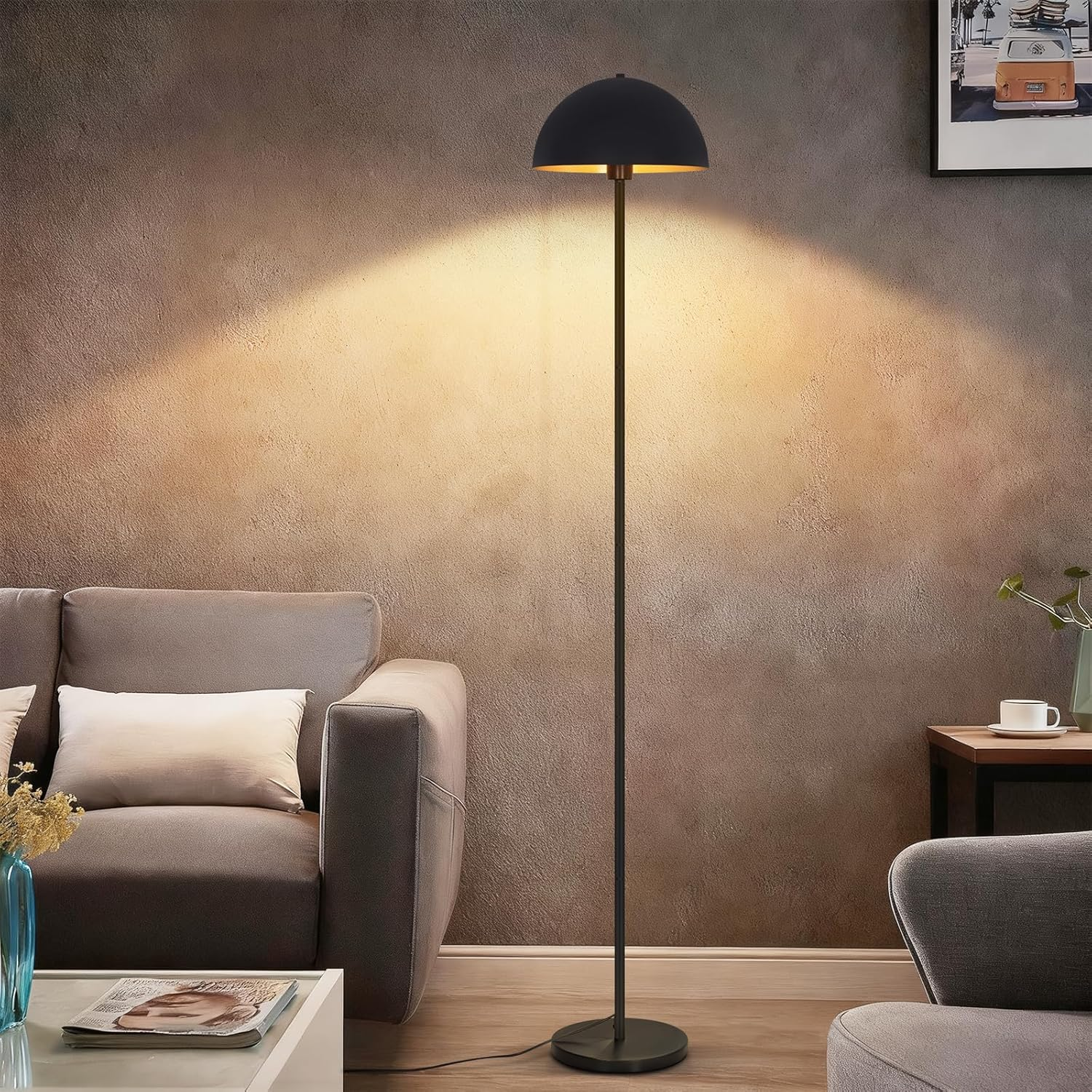 Schwarze Stehlampe mit Halbkugelschirm strahlt warmes Licht gegen eine strukturierte Wand im Wohnzimmer.