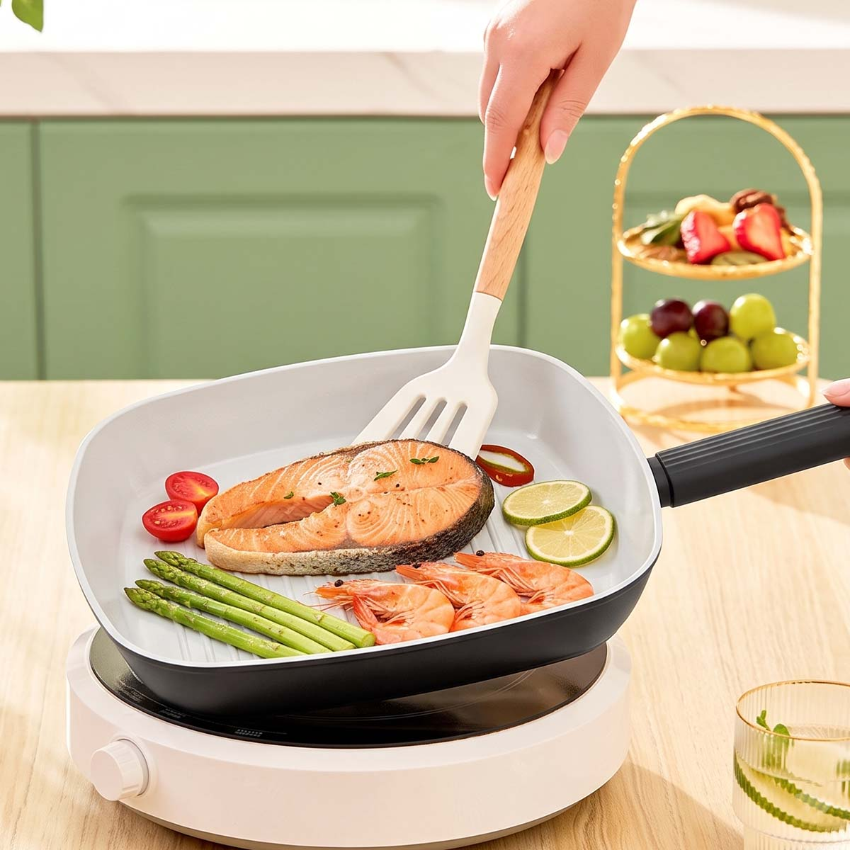 Una mano usa una espátula para voltear salmón, espárragos, camarones, limas y tomates en una sartén cuadrada.