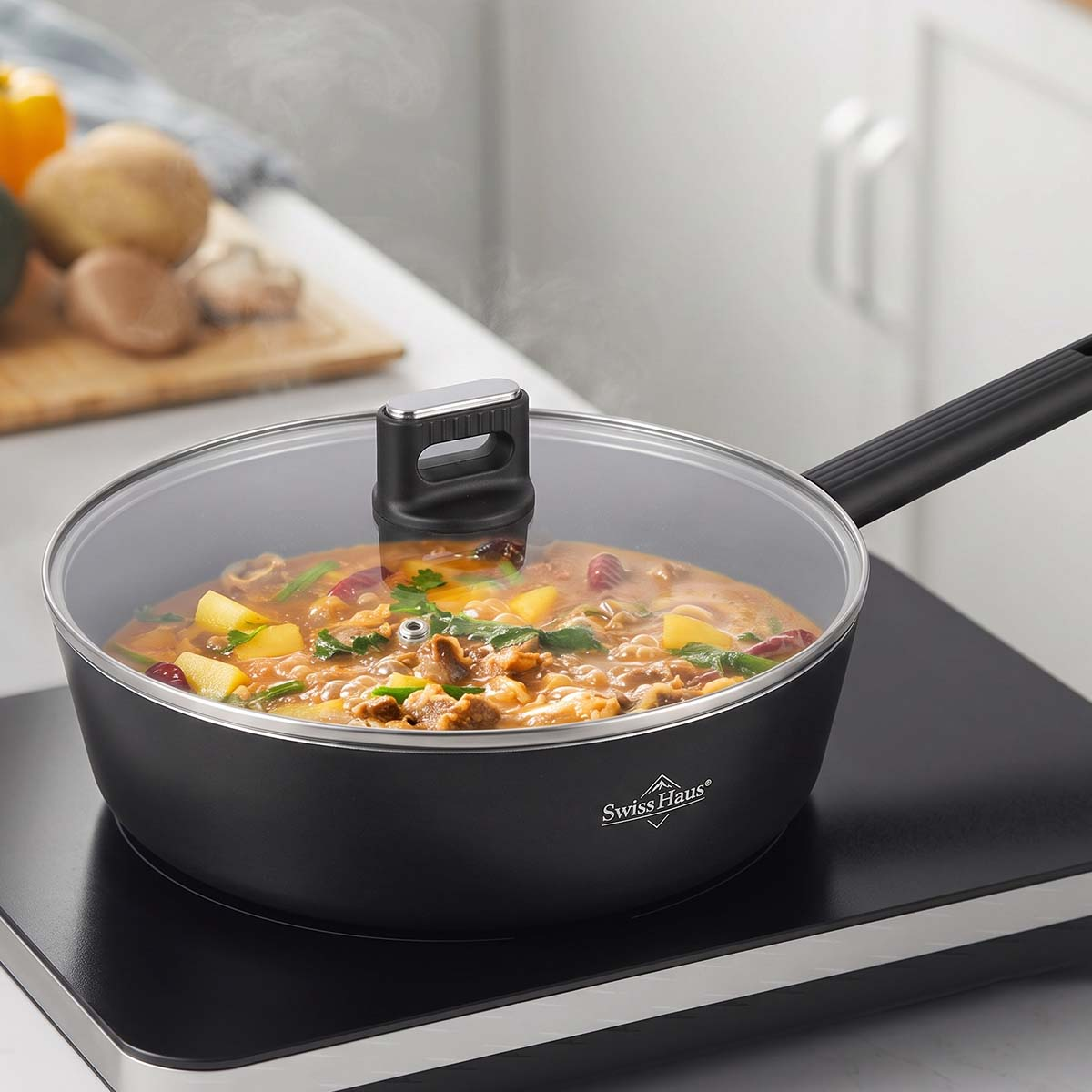 Una sartén negra Swiss Haus con tapa de vidrio cocina una abundante sopa de verduras en una estufa de inducción.