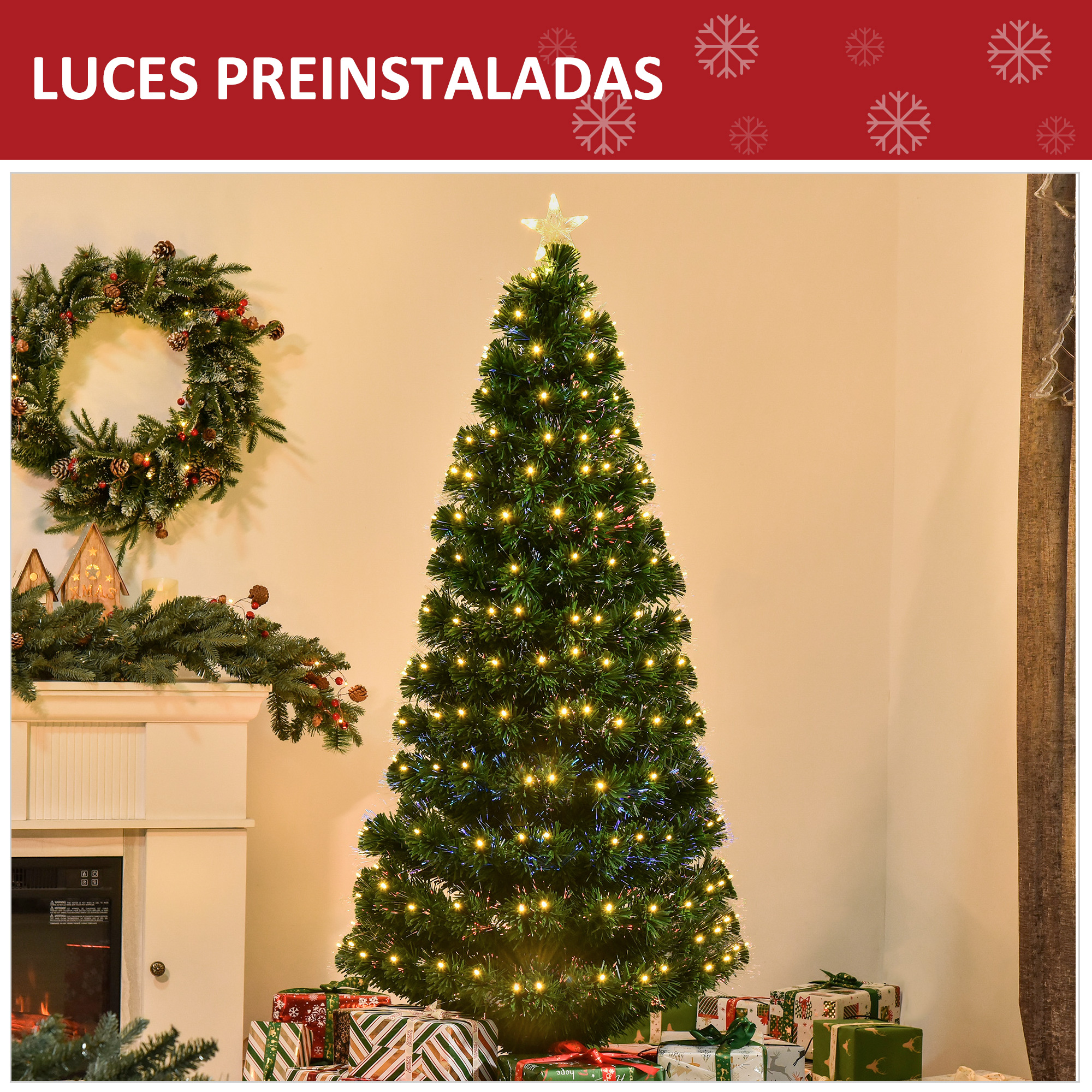 Un árbol de Navidad iluminado se encuentra frente a una pared con chimenea, corona y regalos.
