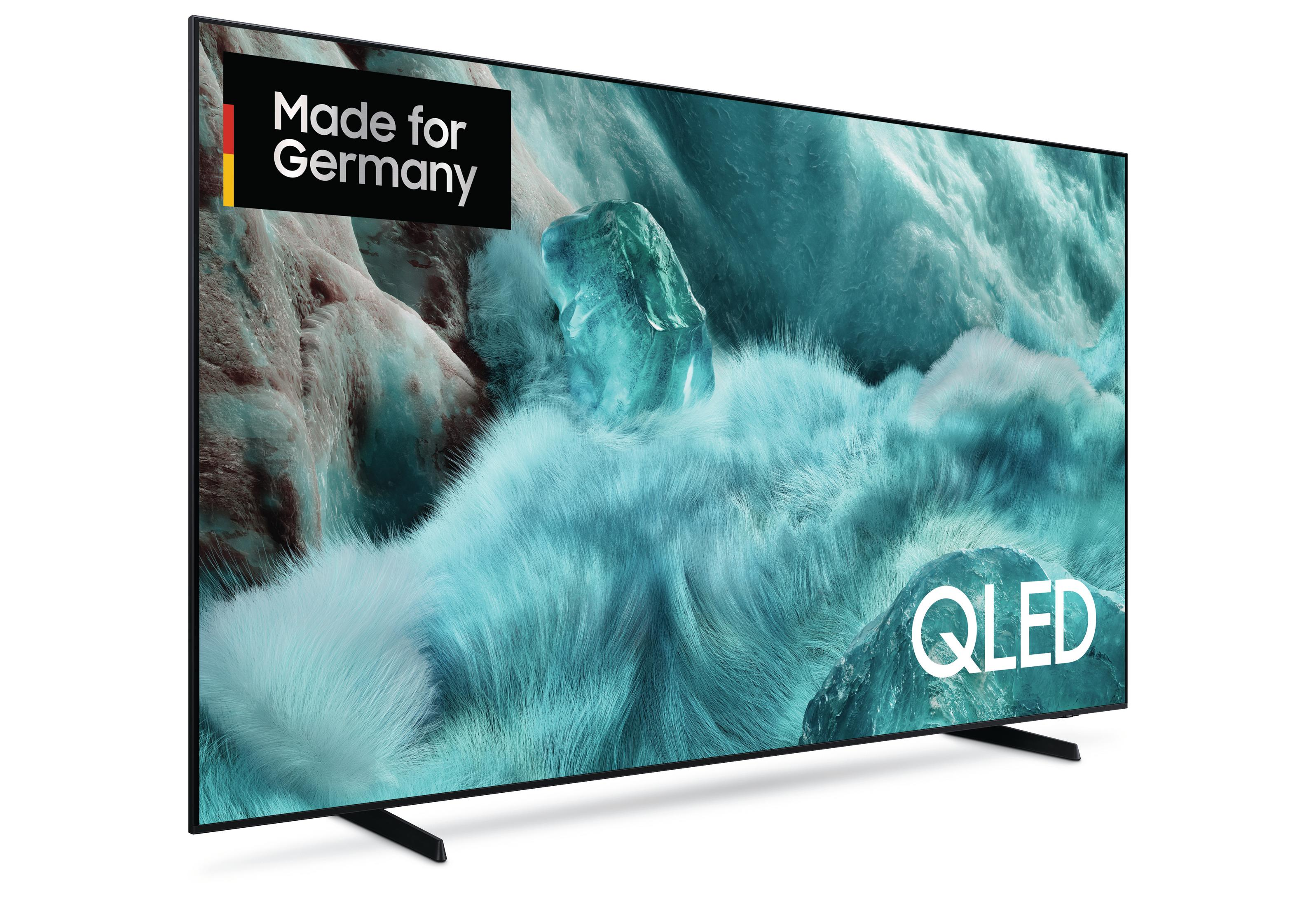 Un televisore QLED mostra una scena astratta blu-turchese con il logo della bandiera tedesca e la scritta.