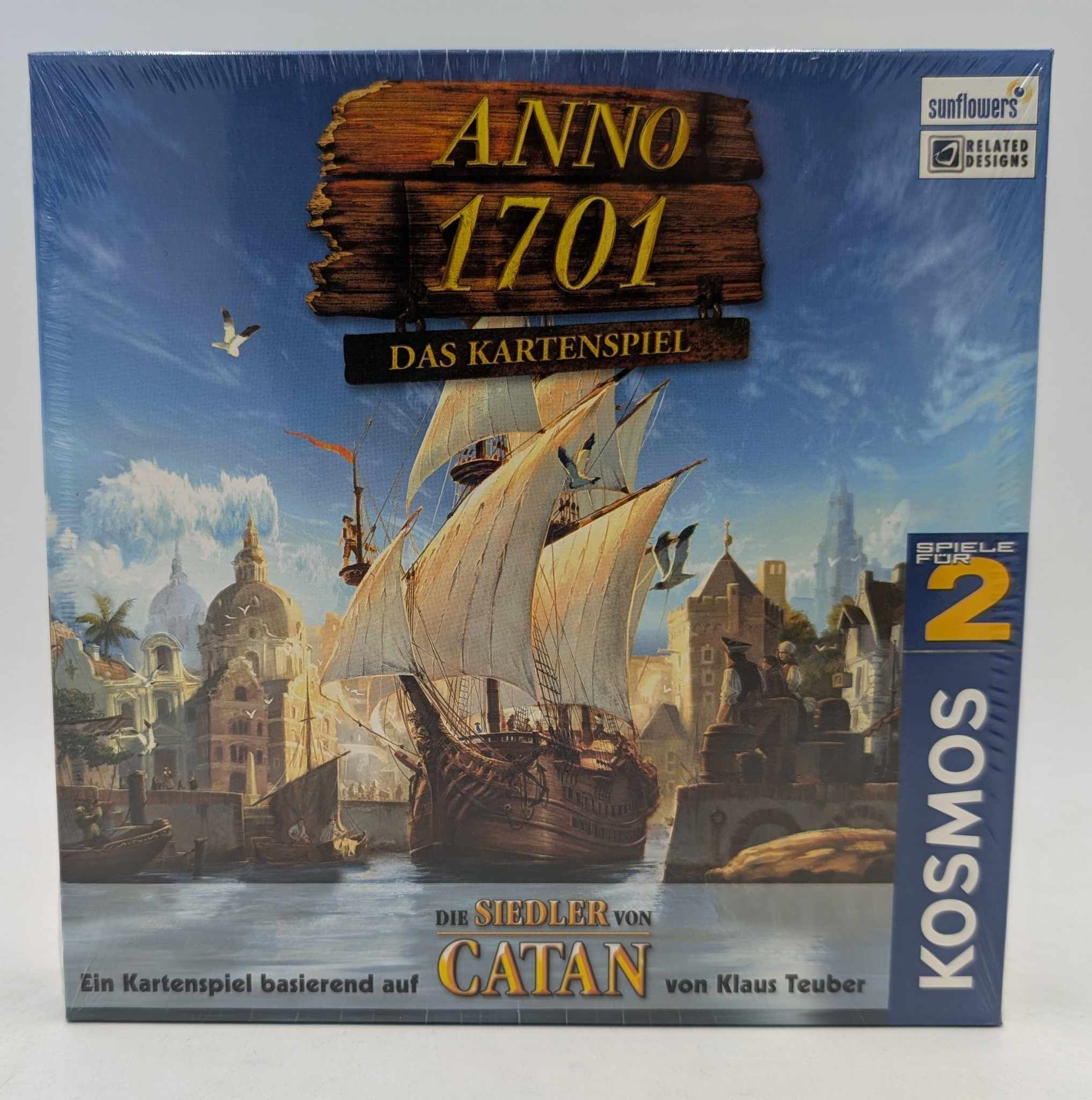 Brettspielverpackung von Anno 1701 Das Kartenspiel mit einem großen Segelschiff vor einer historischen Hafenstadt.