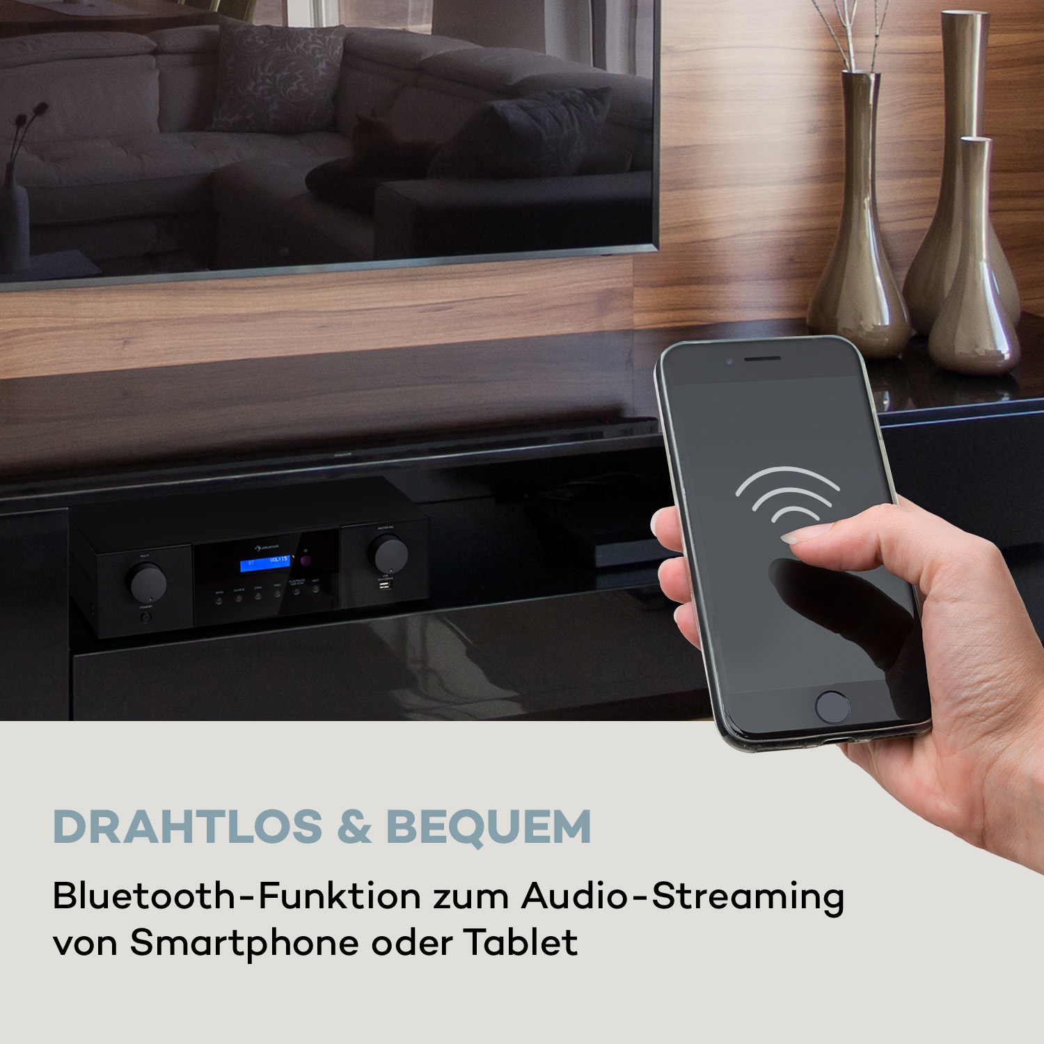 Hand hält Smartphone mit WLAN-Symbol vor Fernseher und Stereoanlage.