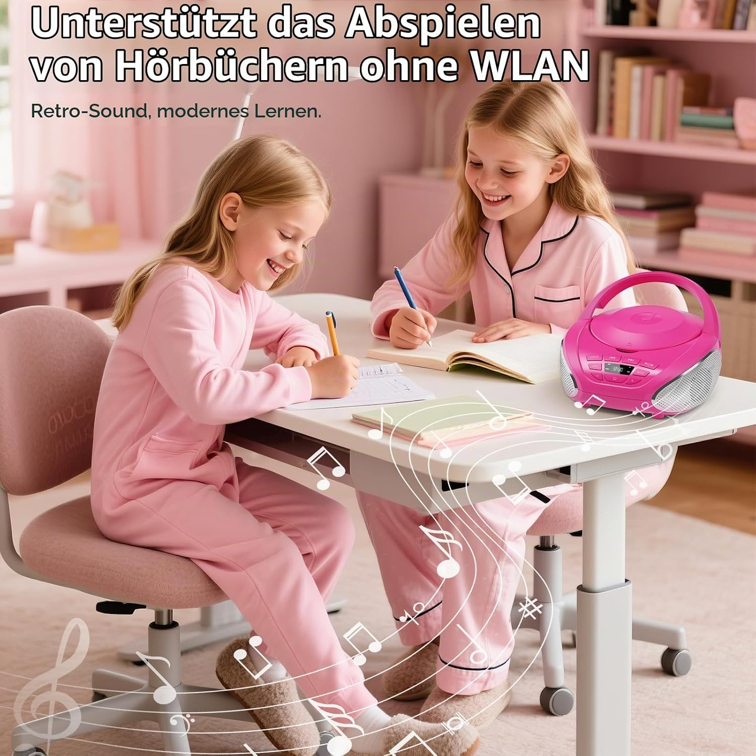 Zwei Mädchen in rosa Schlafanzügen sitzen am Tisch und schreiben, neben ihnen steht ein pinker Kassettenrekorder.