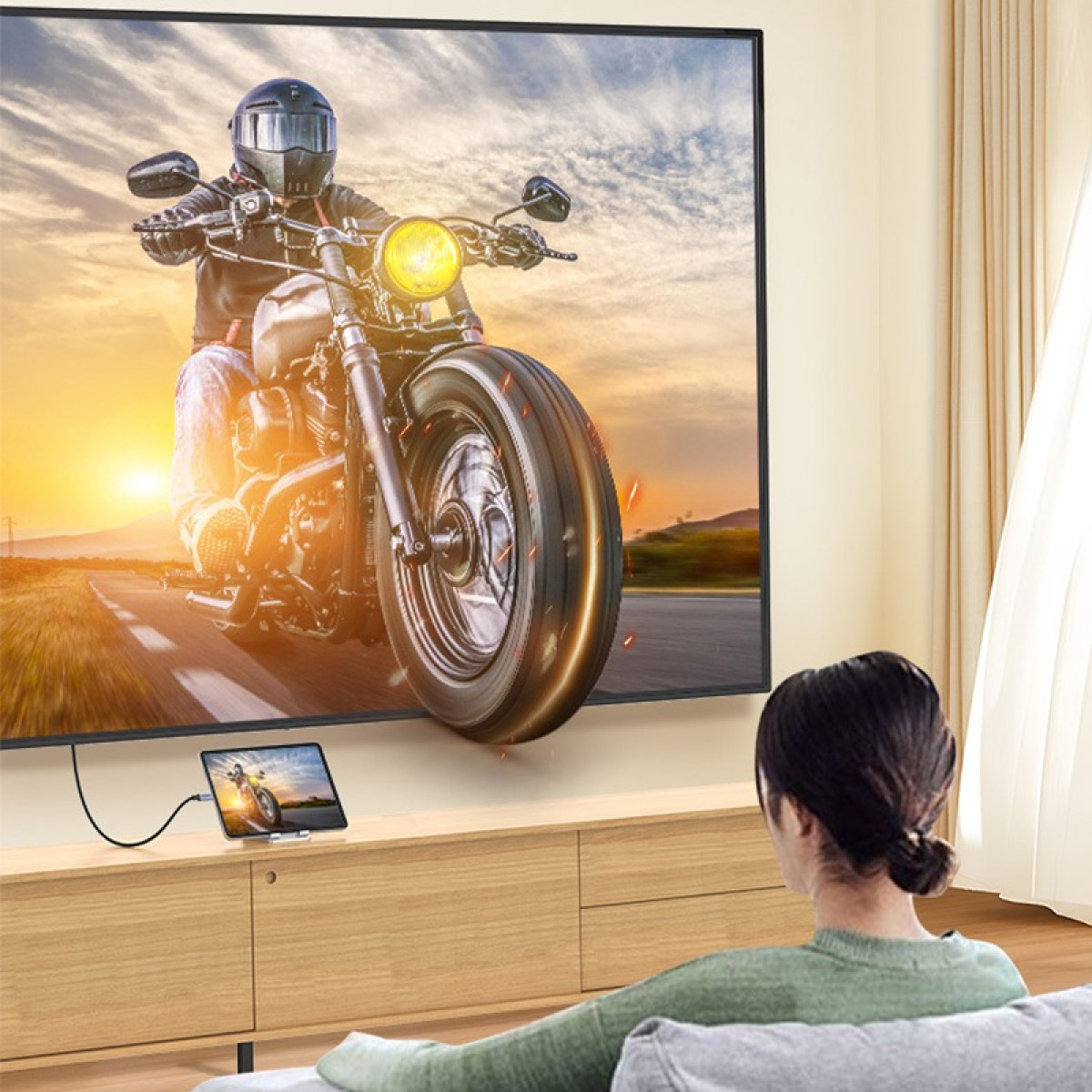 Eine Frau schaut Fernsehen, auf dem ein Motorrad aus dem Bildschirm zu fahren scheint.