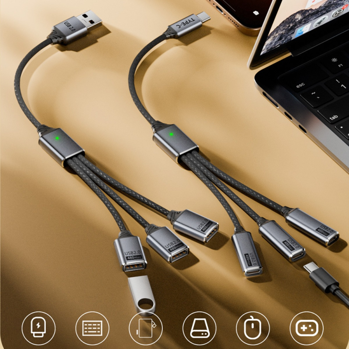 Zwei graue Multi-USB-Hub-Kabel mit mehreren Anschlüssen liegen auf einer gelben Oberfläche neben einem Laptop.
