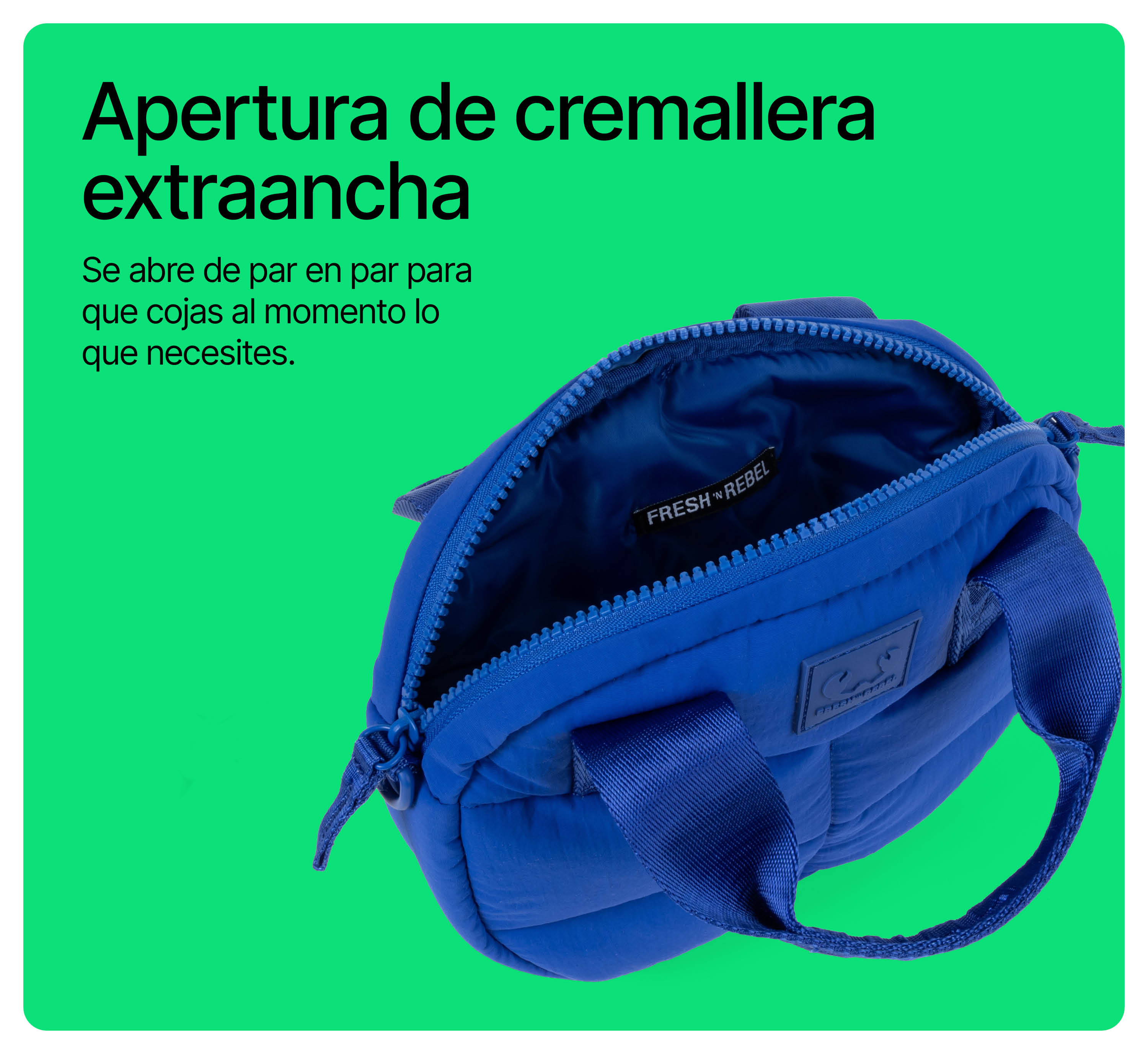 Bolso acolchado azul con cremallera ancha sobre fondo verde.