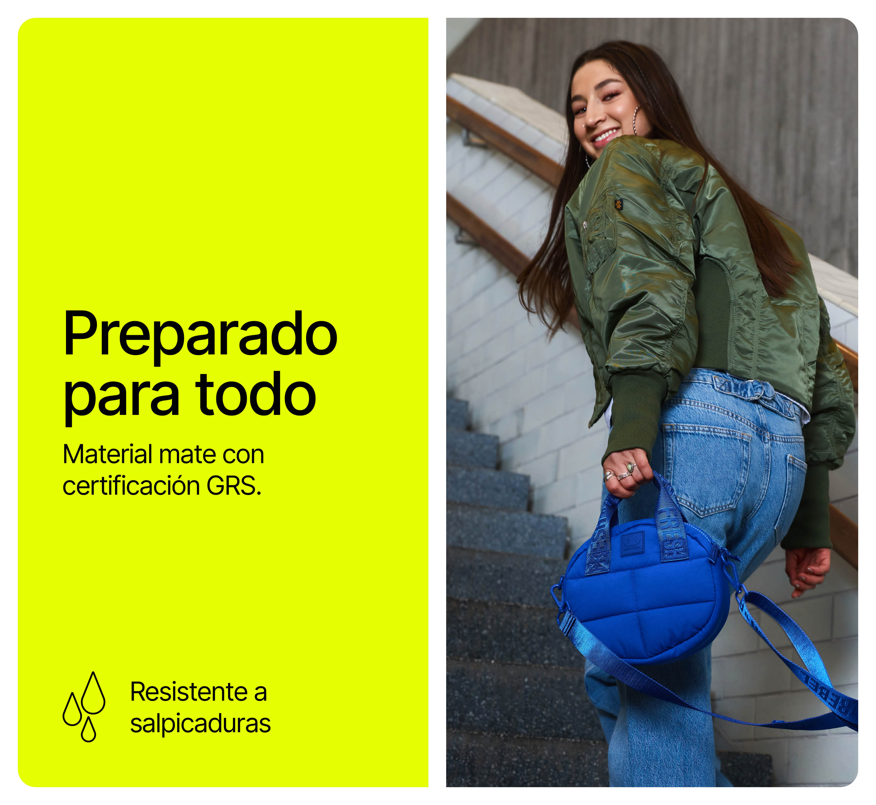 Una mujer con chaqueta bomber verde y vaqueros sube escaleras sosteniendo un bolso azul.