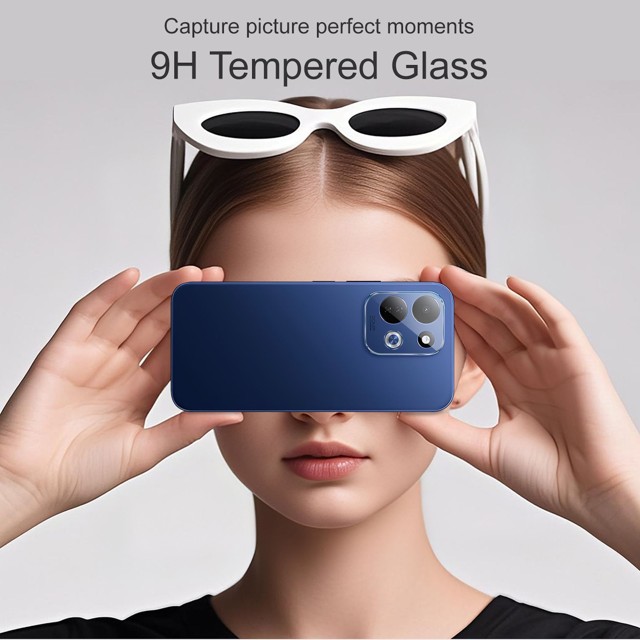 Eine Frau hält ein blaues Smartphone vor ihr Gesicht. Auf ihrem Kopf trägt sie eine weiße Sonnenbrille.
