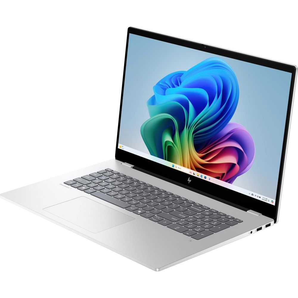 Un laptop argento con tastiera nera mostra uno sfondo astratto e colorato sullo schermo.
