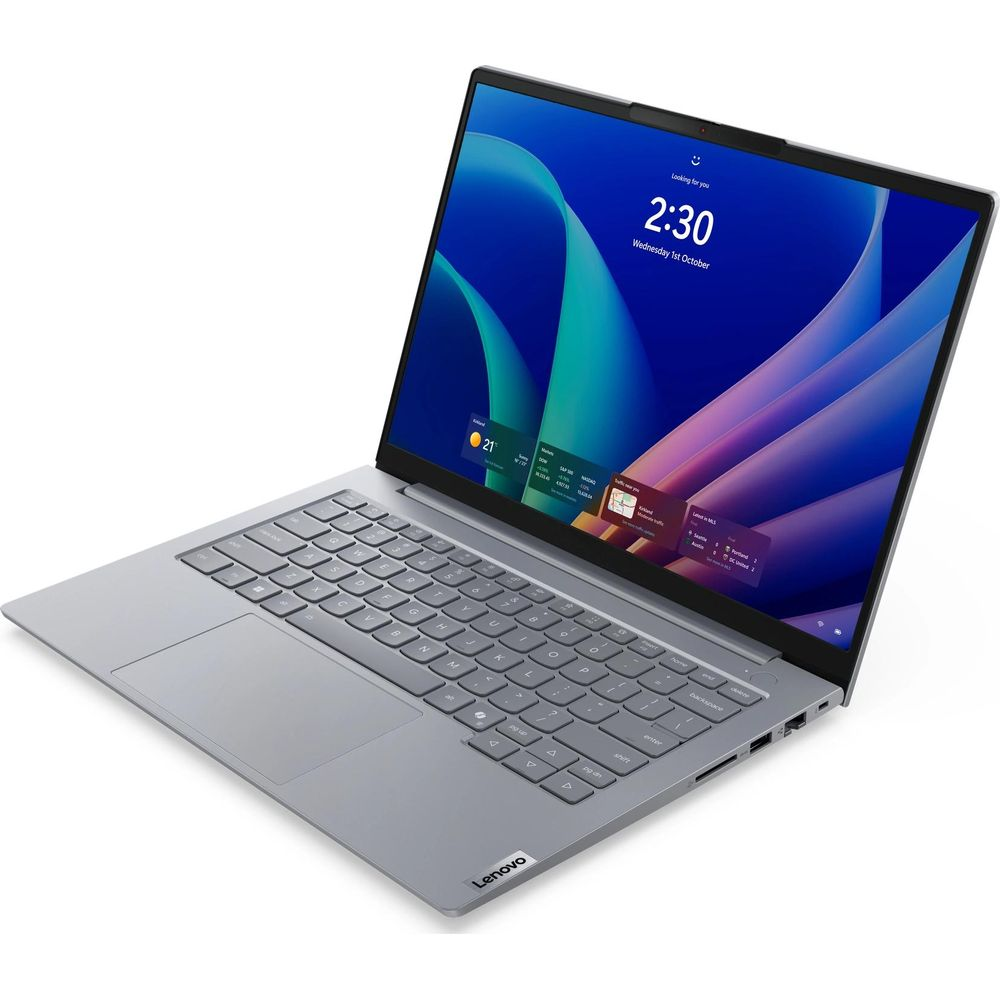 Un computer portatile argentato con schermo blu su una superficie bianca.
