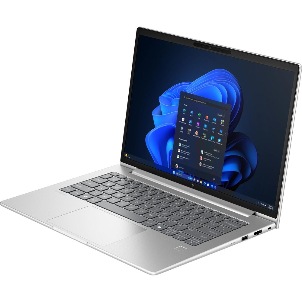 Un laptop argentato con tastiera nera e sfondo blu su sfondo bianco.