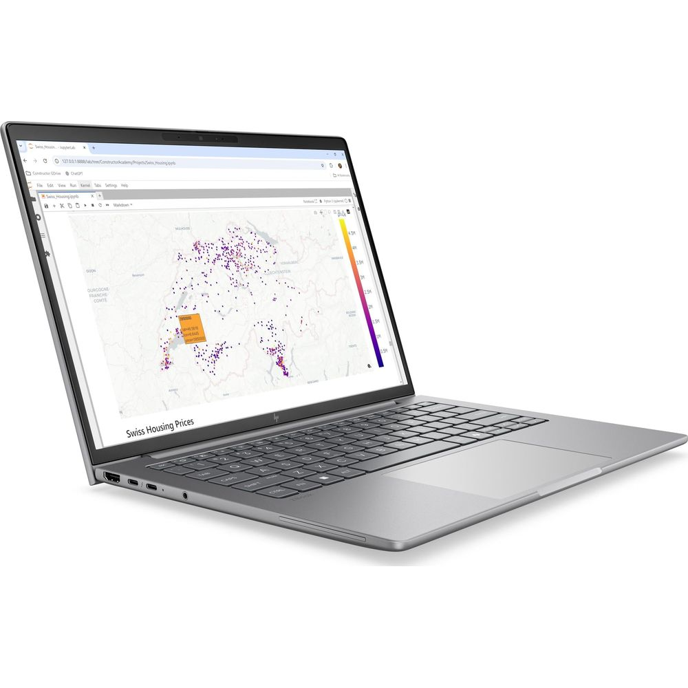 Un laptop argento mostra una mappa dei prezzi delle case in Svizzera sullo schermo su sfondo bianco.