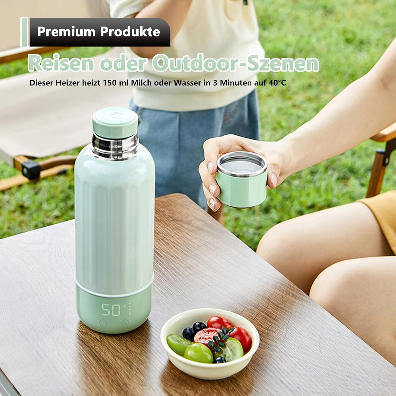 Grüne Thermosflasche mit Digitaldisplay und Becher auf einem Holztisch im Freien.