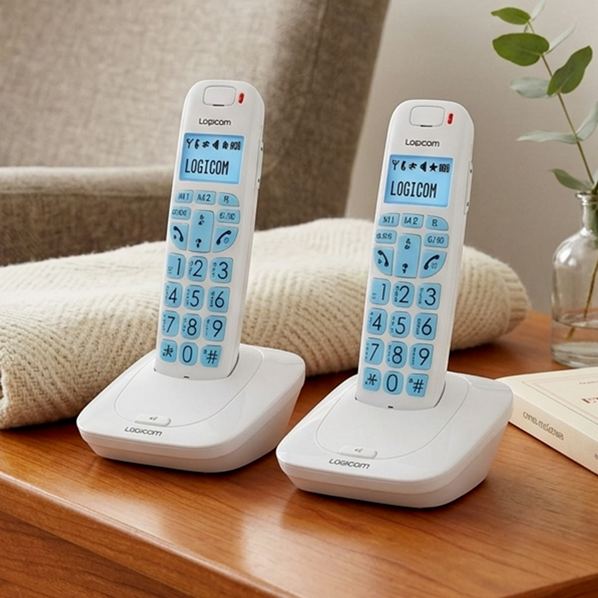 Zwei weiße kabellose Logicom-Festnetztelefone mit blauen Tasten auf Ladestationen auf einem Holztisch.