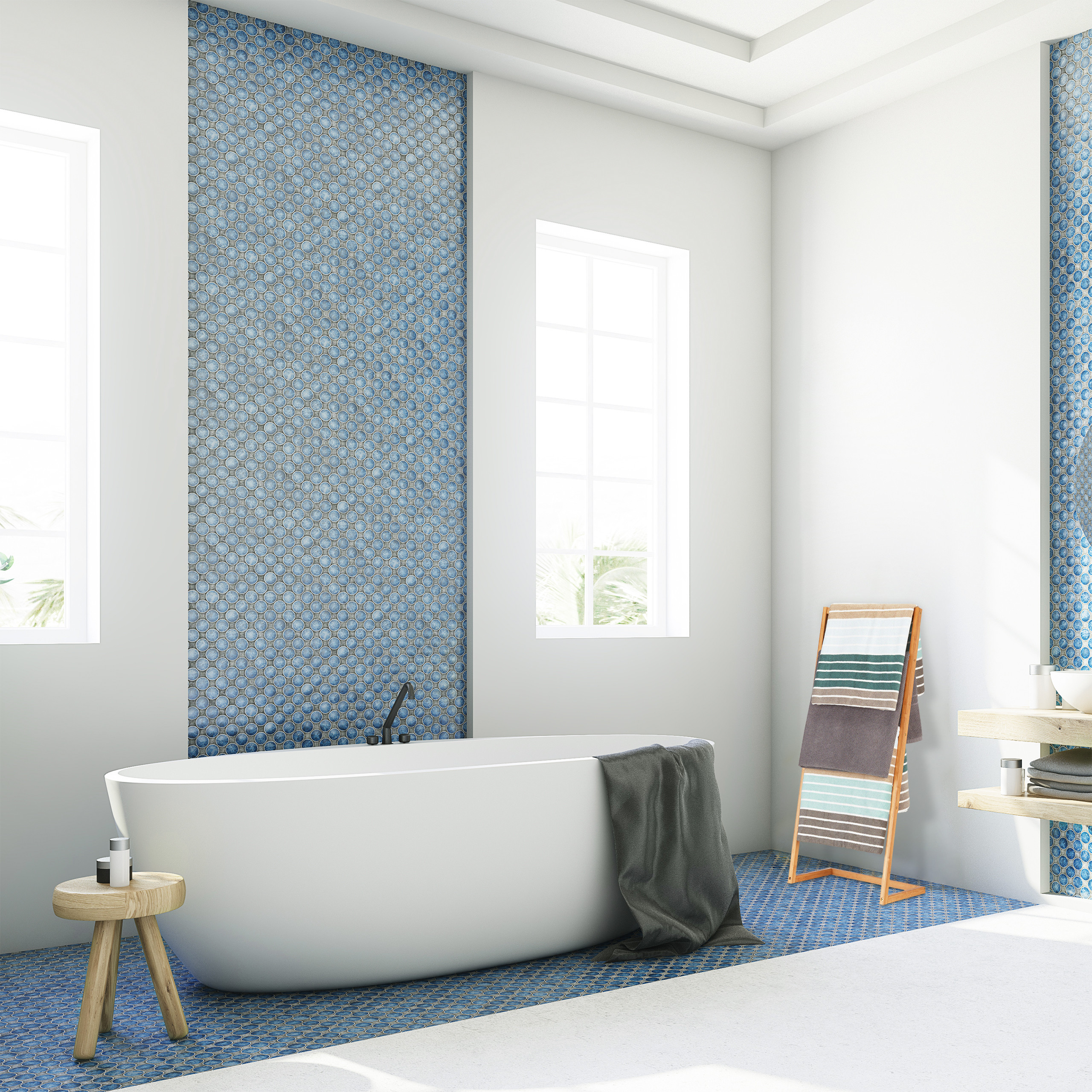 Moderne Badezimmer mit weißer Wanne, blauen Mosaikfliesen, Holztisch und Handtuchhalter vor Fenstern.