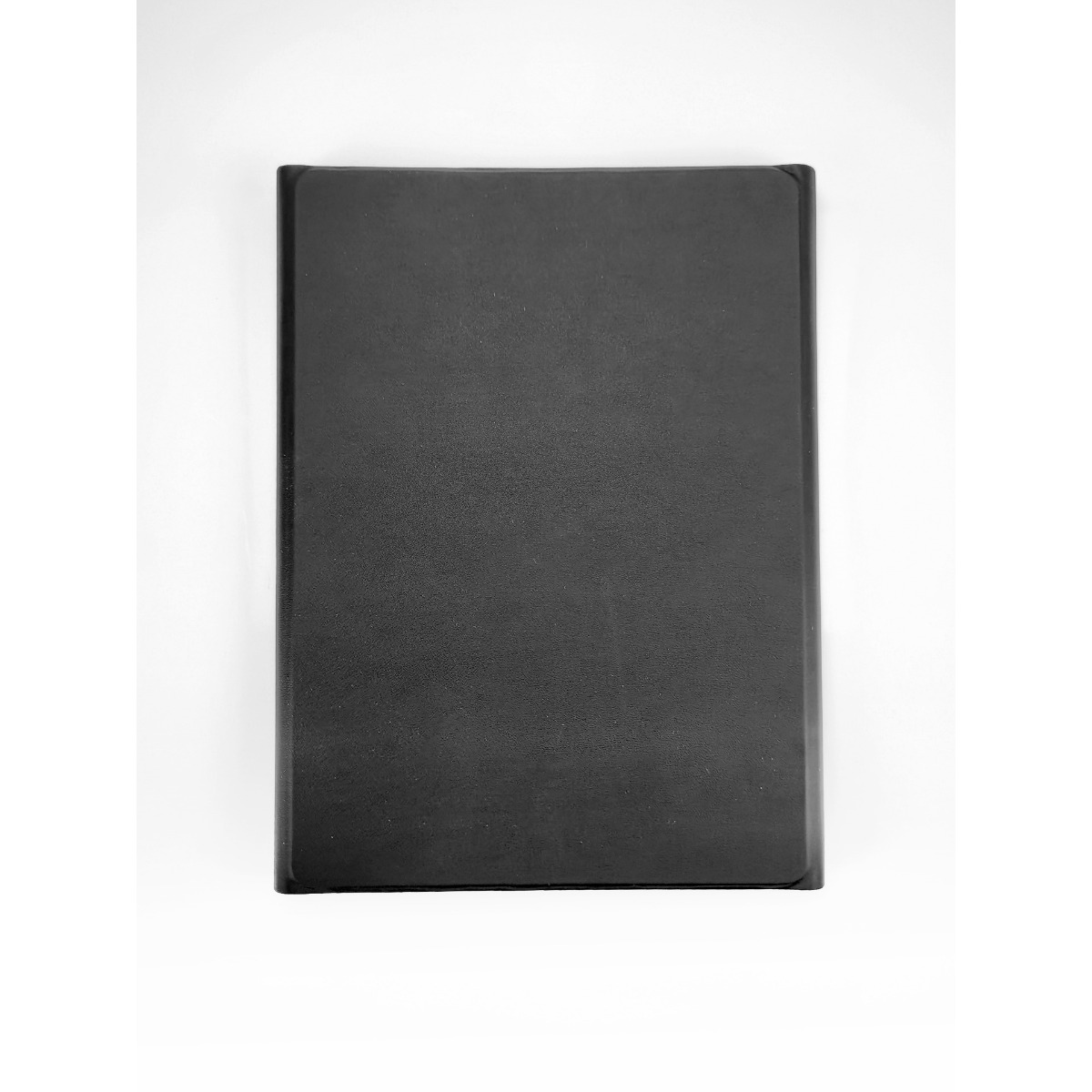Ein geschlossenes schwarzes Buch liegt flach auf einer hellen Oberfläche.