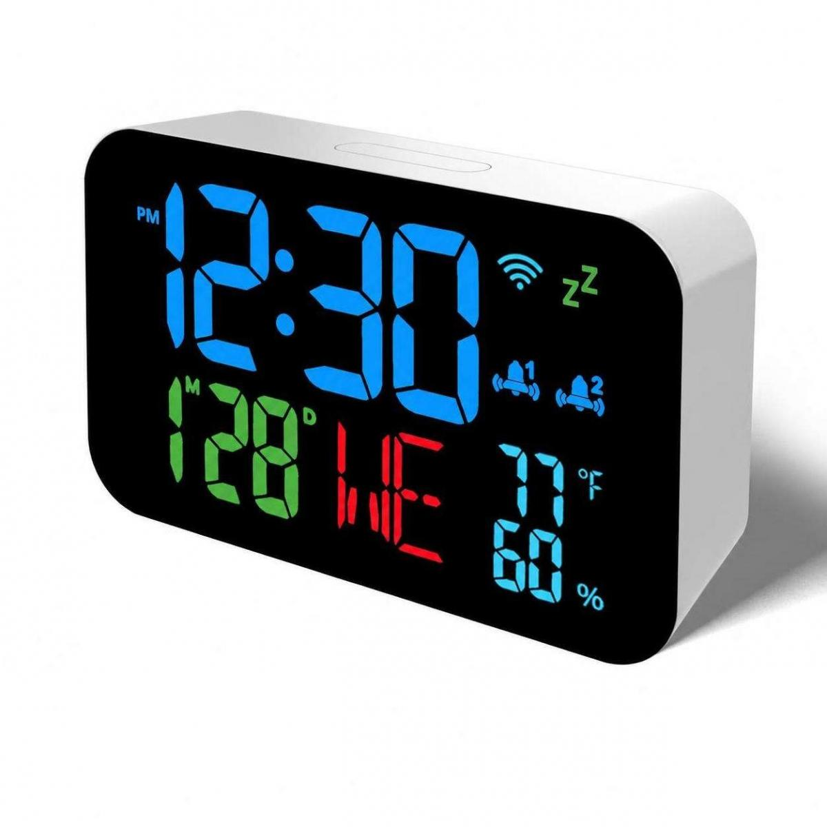 Ein weißer digitaler Wecker mit blauem, grünem und rotem Display zeigt die Uhrzeit, das Datum und Symbole.