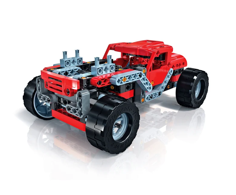 Un coche de juguete de plástico rojo hecho de bloques con neumáticos negros grandes sobre una superficie blanca.