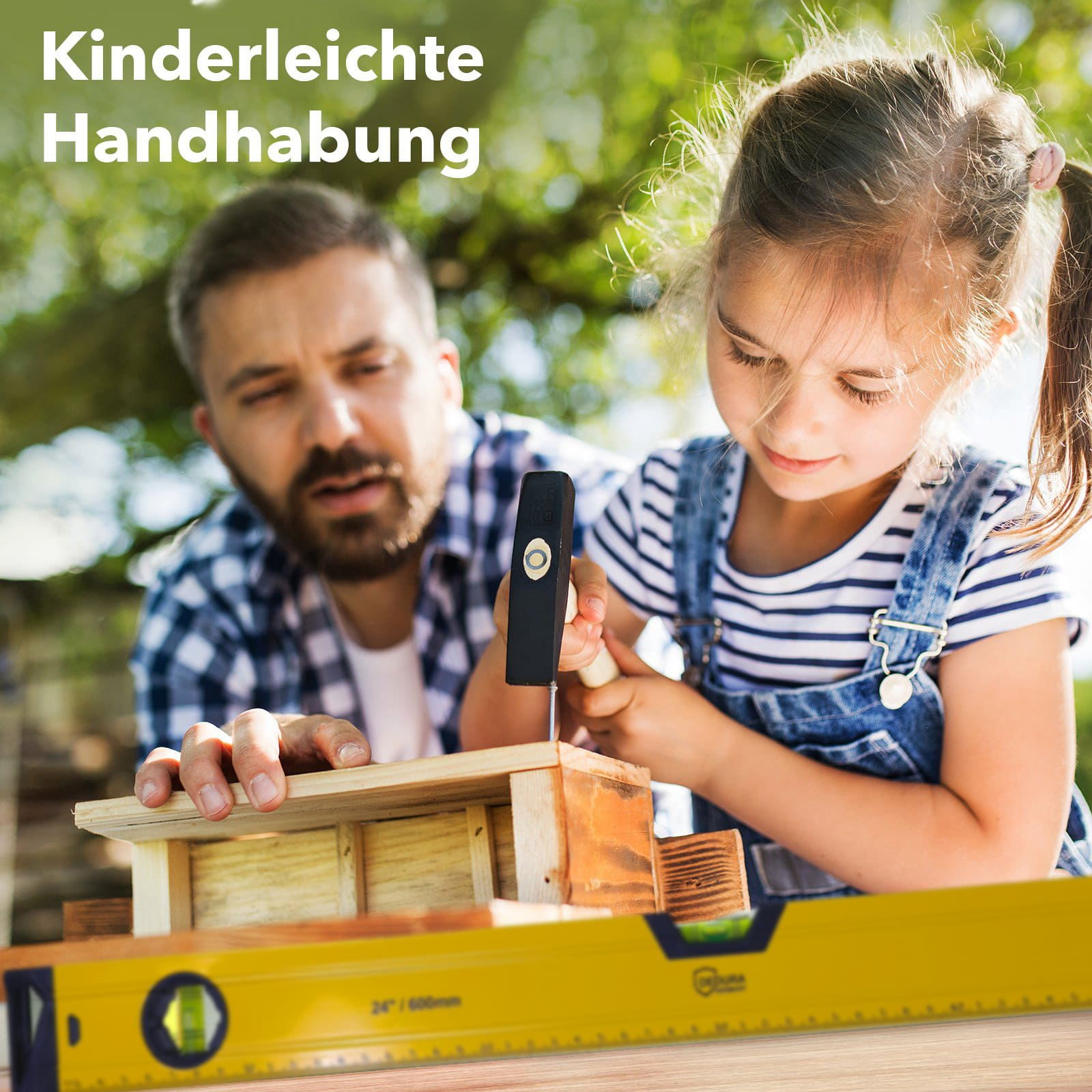 Ein Mann und ein Mädchen bauen zusammen ein Holzhaus. Das Mädchen hämmert einen Nagel ein, während der Mann zusieht.