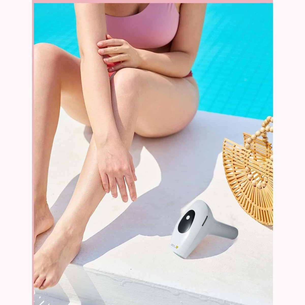 Eine Frau in einem rosa Bikini sitzt am Pool, neben einem Haarentfernungsgerät und einer geflochtenen Tasche.