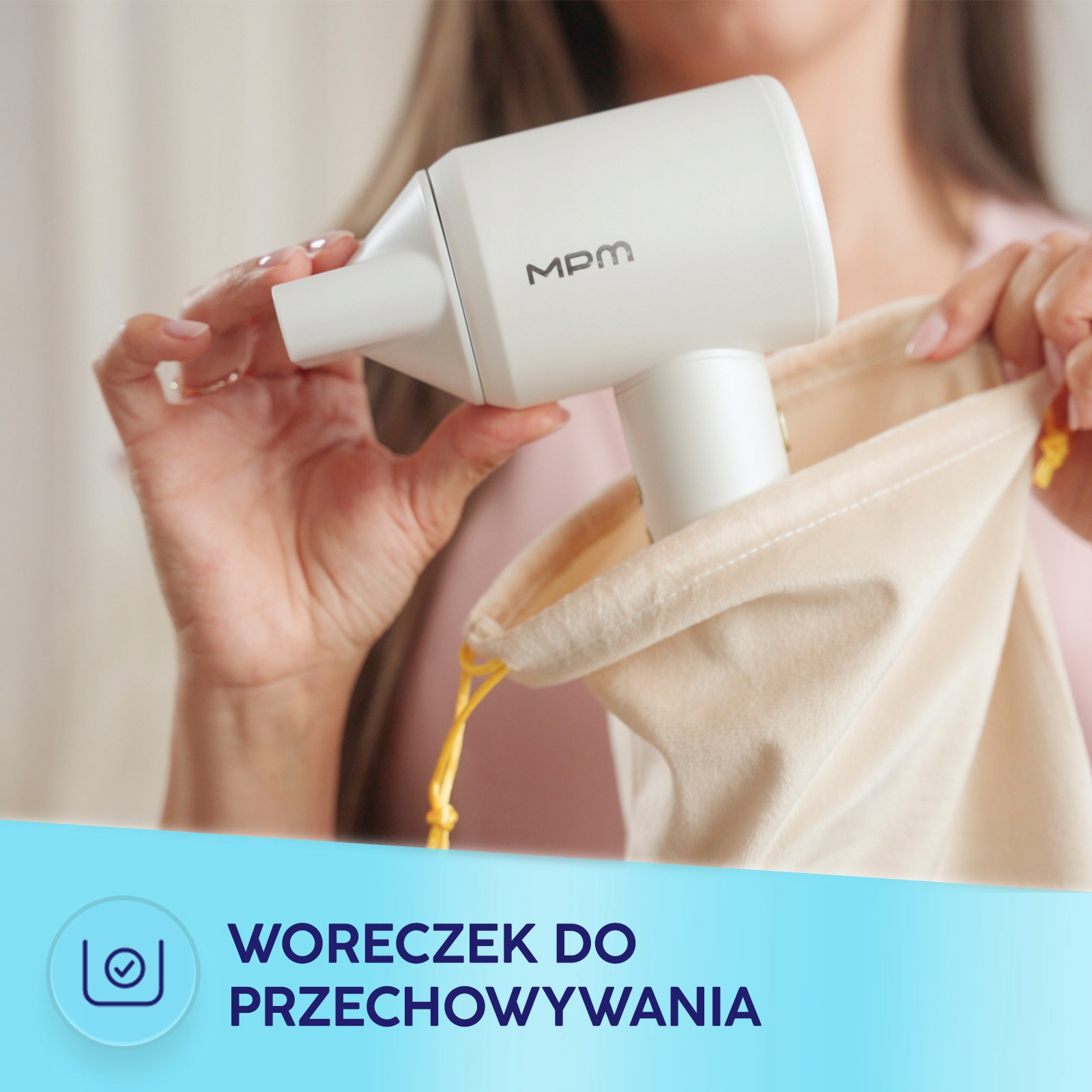 Kobieta wkłada biały odkurzacz ręczny do beżowego worka do przechowywania. Tekst na dole: WORECZEK DO PRZECHOWYWANIA.
