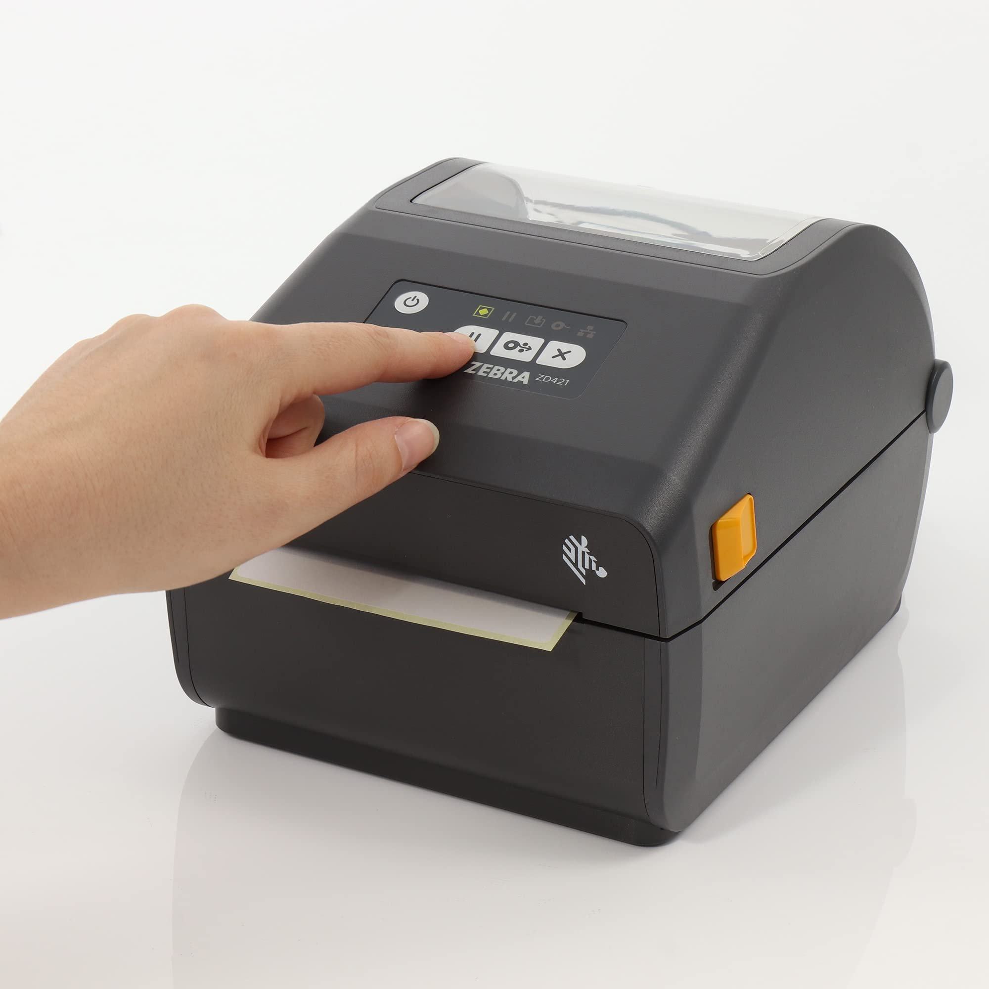 Une main appuie sur un bouton d'une imprimante Zebra ZD421 noire sur fond blanc.