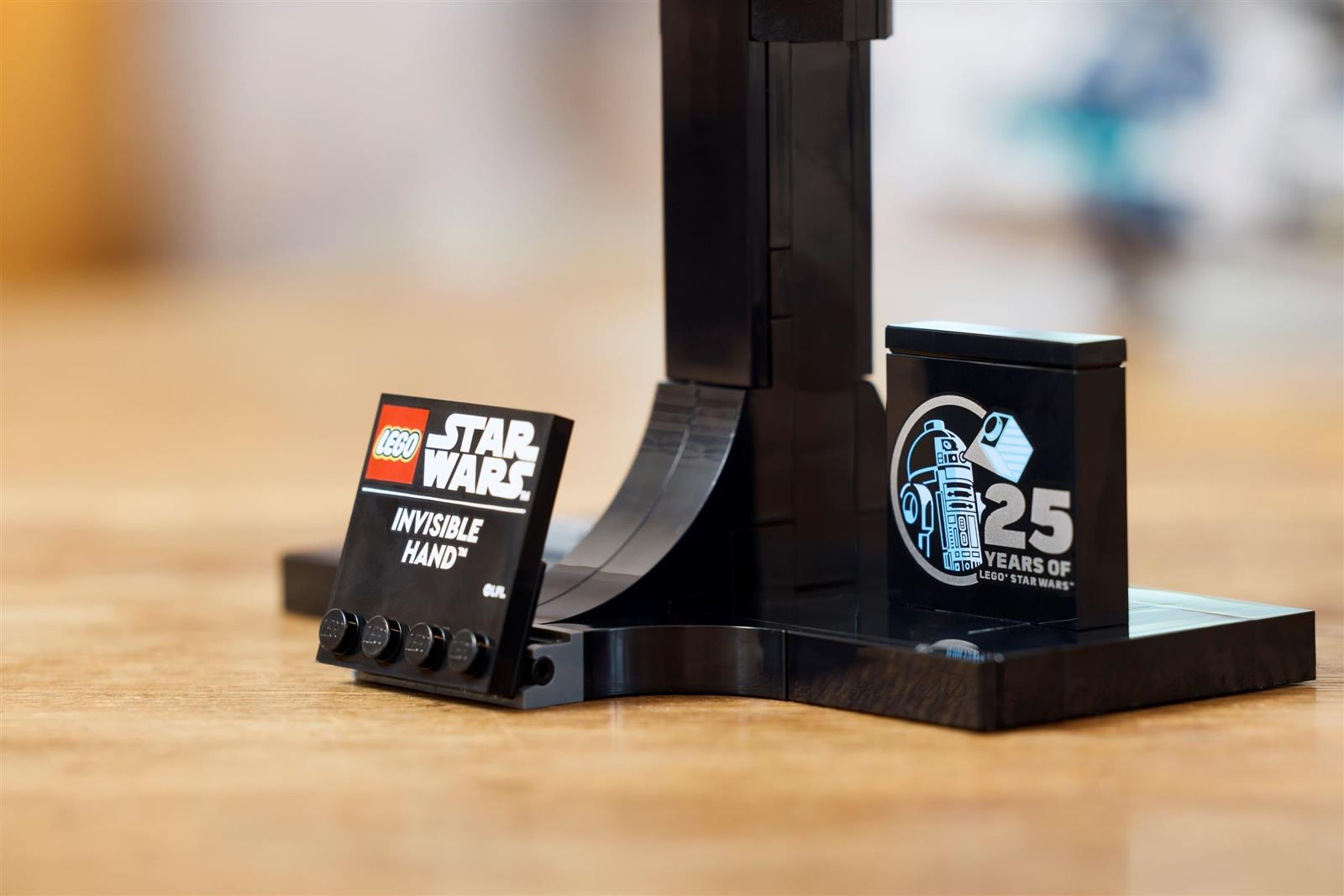Lego Star Wars Invisible Hand Ständer mit 25-Jahre-Jubiläumsstein auf einem Holztisch.