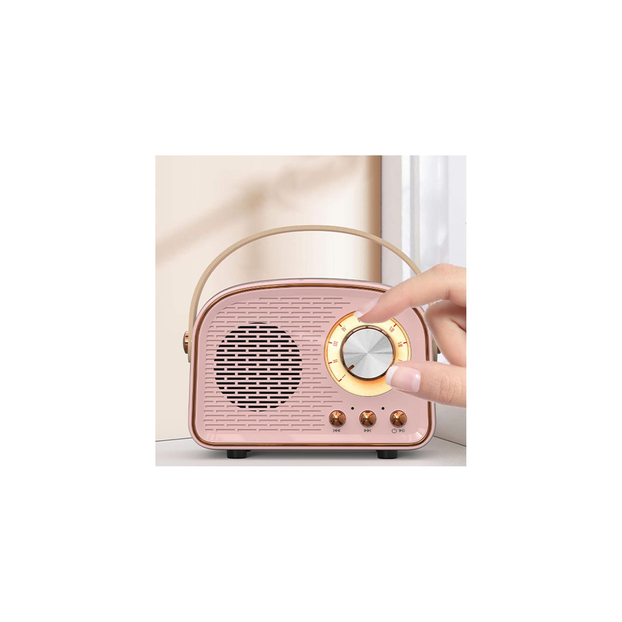 Eine Hand verstellt den Lautstärkeregler eines rosa-goldenen Retro-Radios mit Tragegurt.