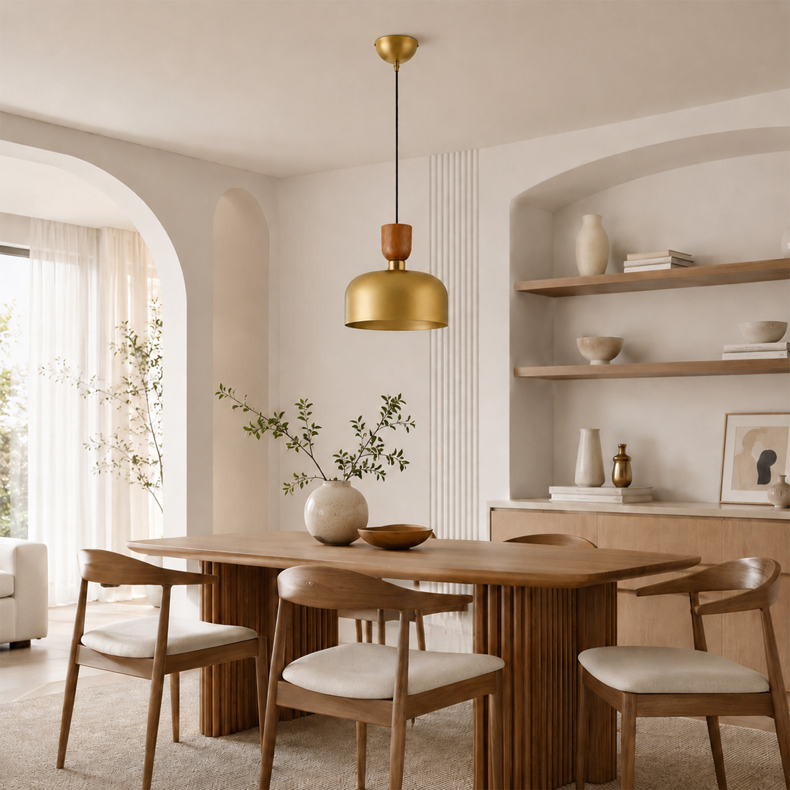 Comedor moderno con mesa de madera, sillas con cojines blancos, lámpara colgante dorada y estantes con decoración.