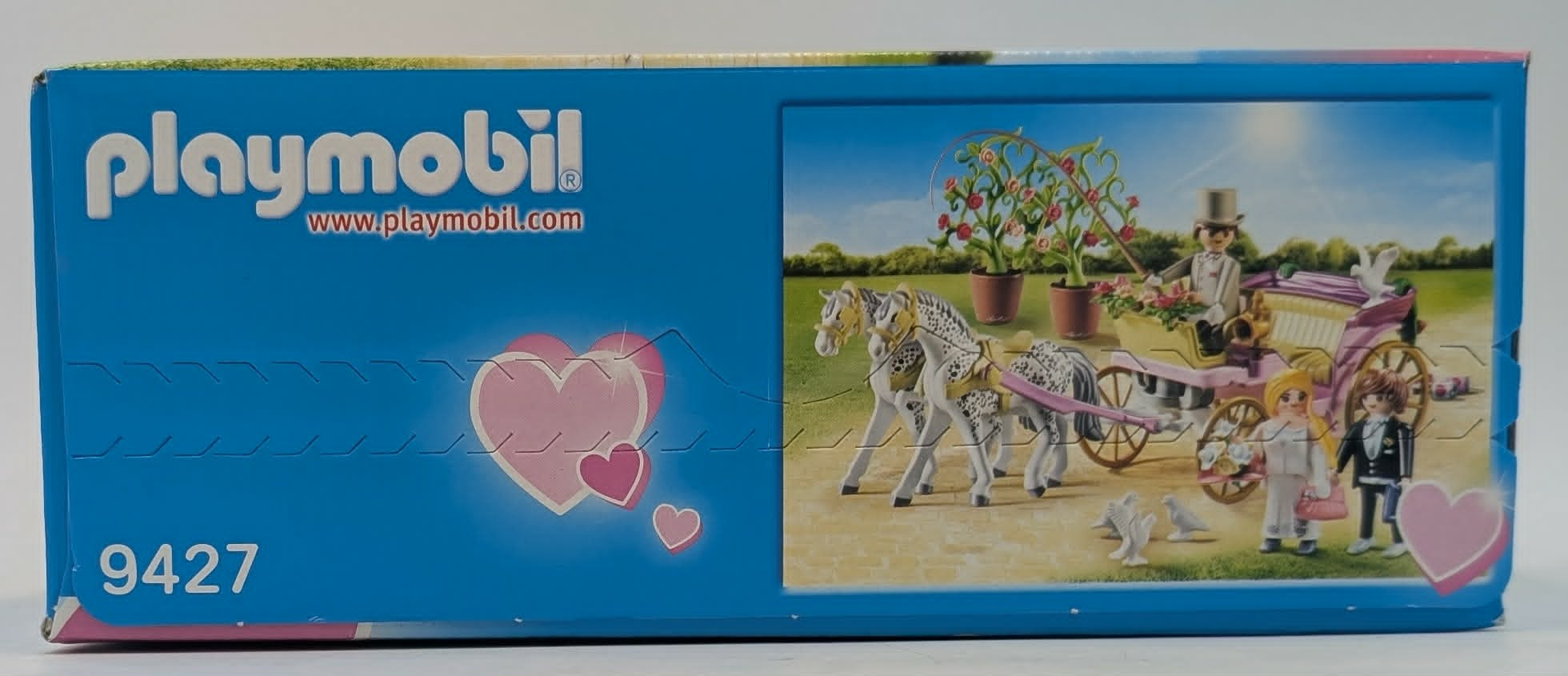 Playmobil Hochzeitkutsche mit zwei Pferden, Kutscher, Braut, Bräutigam, Topfblumen und Tauben im Freien.