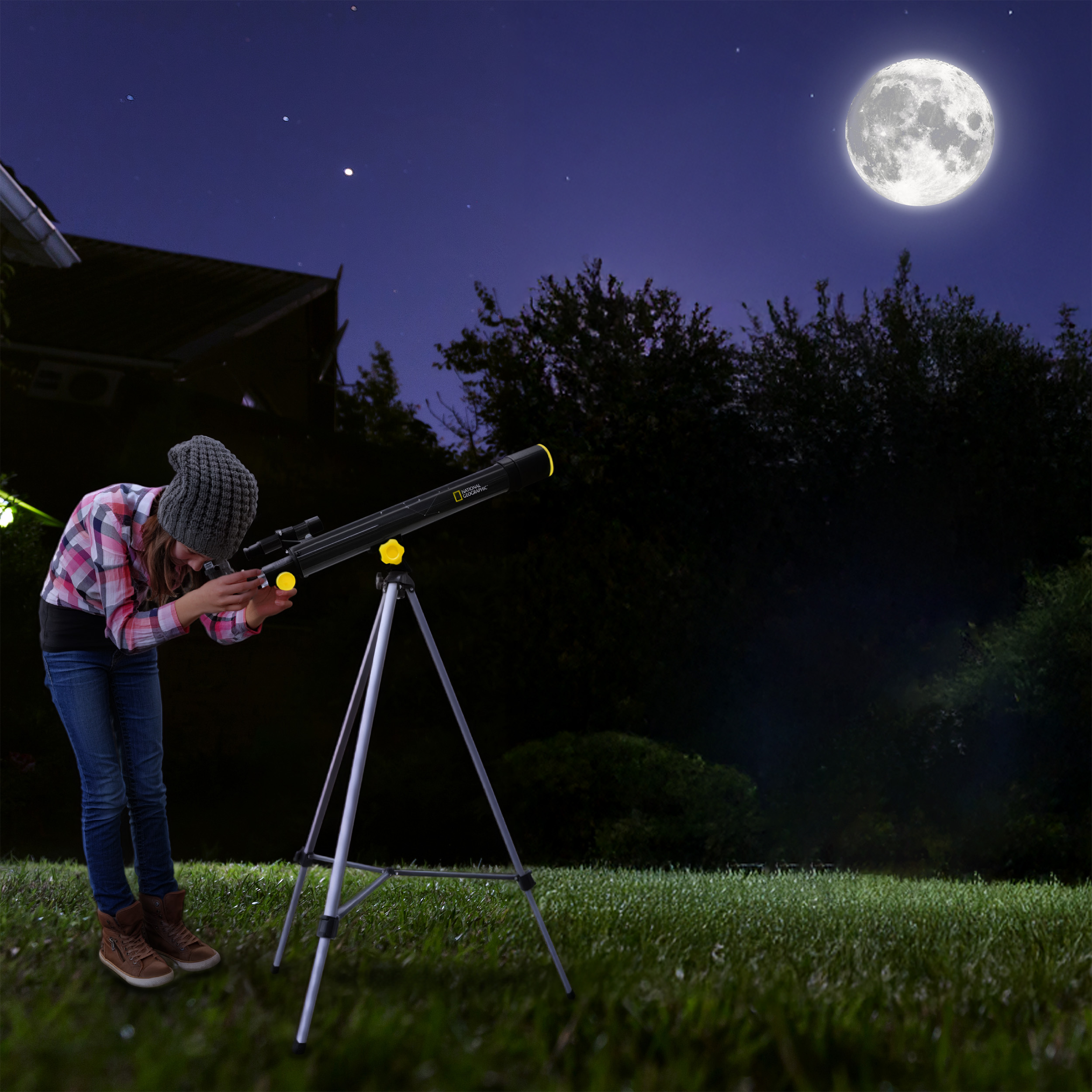 Una niña con gorro mira a través de un telescopio en un jardín con césped bajo una luna llena brillante y un cielo estrellado.